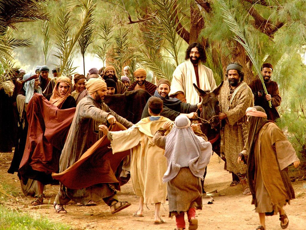 FreeBibleimage - Triumphant Entry - Jesus Rides Triumphantly Into Jerusalem On A Donkey While The Crowds Wave Palm Branches And Shout, 'Hosanna'. An Event Remembered On Palm Sunday (Matthew 21:1 Mark 11:1 Luke 19:28 John 12:12 17)