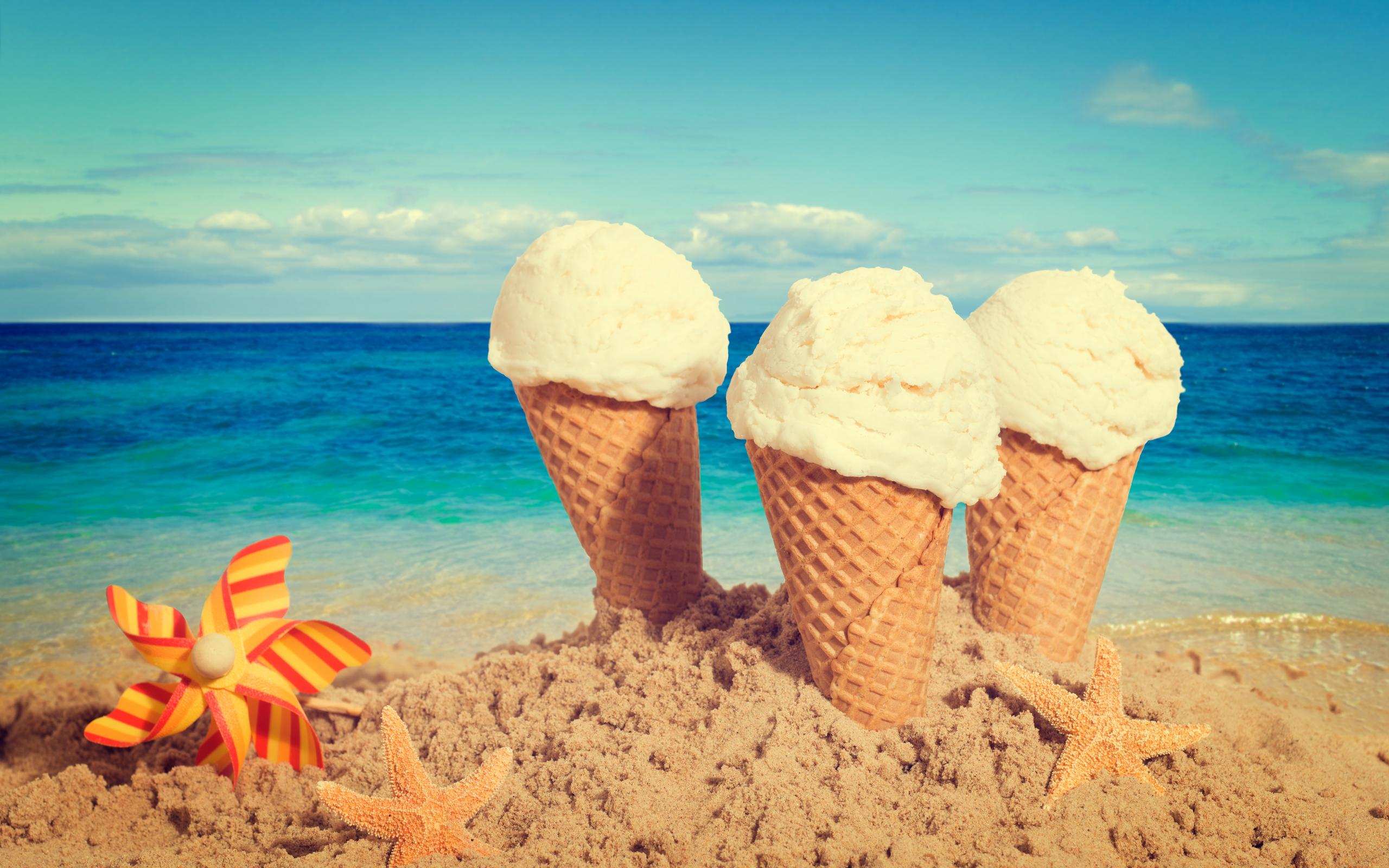 Three vanilla ice cream in the beach sand near starfish