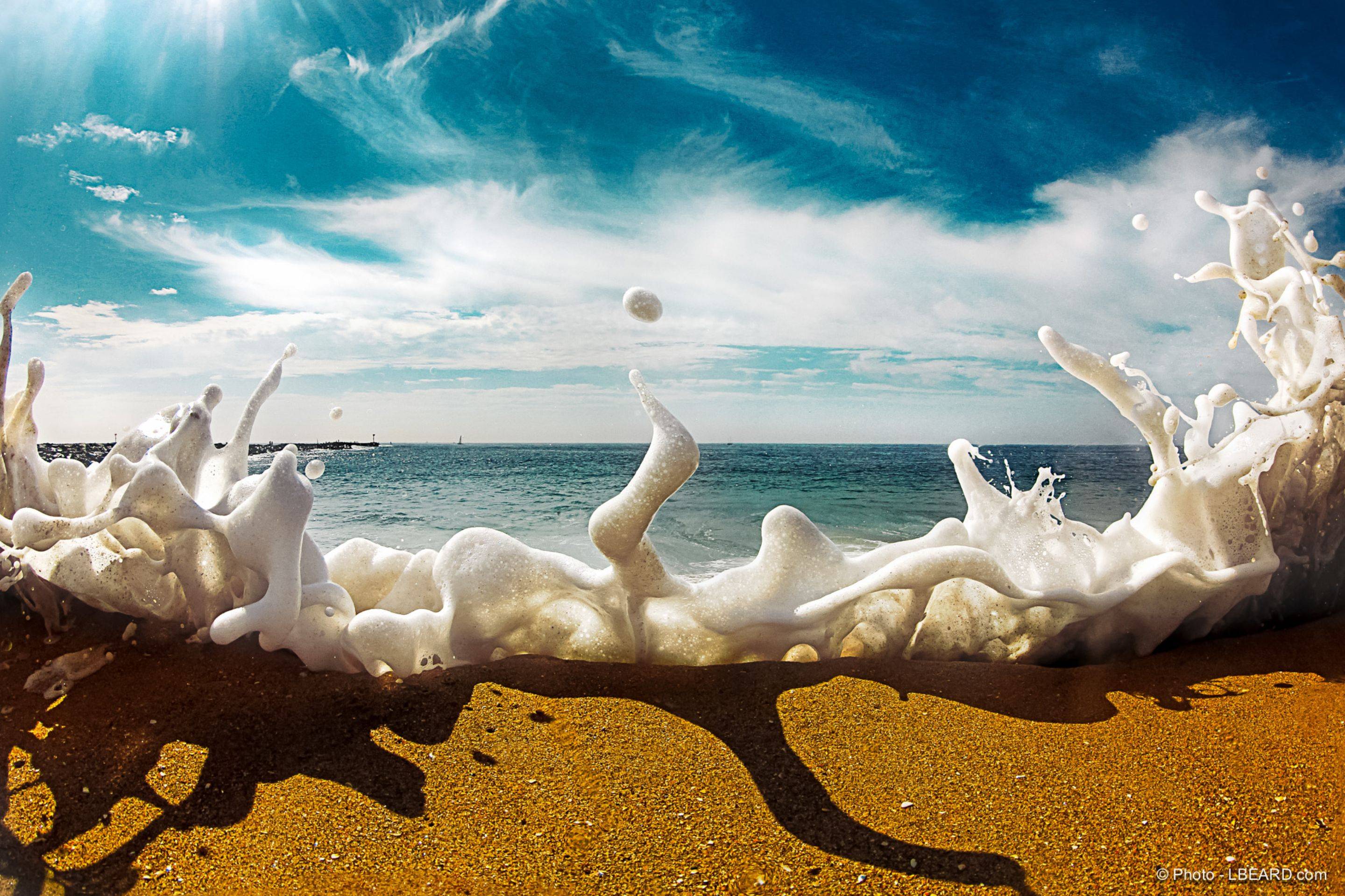 Sea foam crashes over the sand