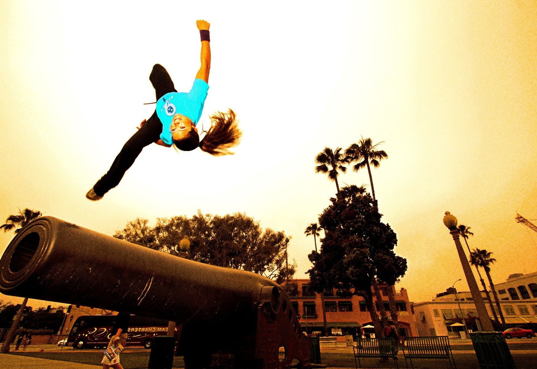 Parkour. She performs a side flip with obstacles