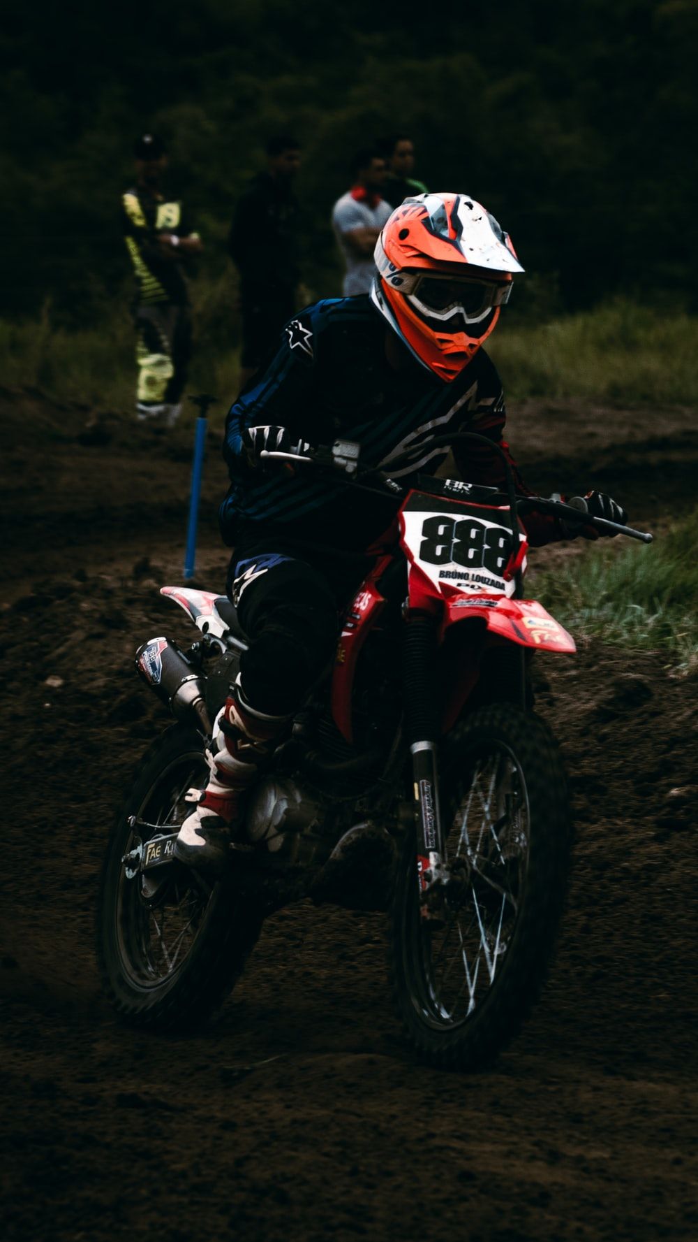 man in red and white motocross suit riding motocross dirt bike photo