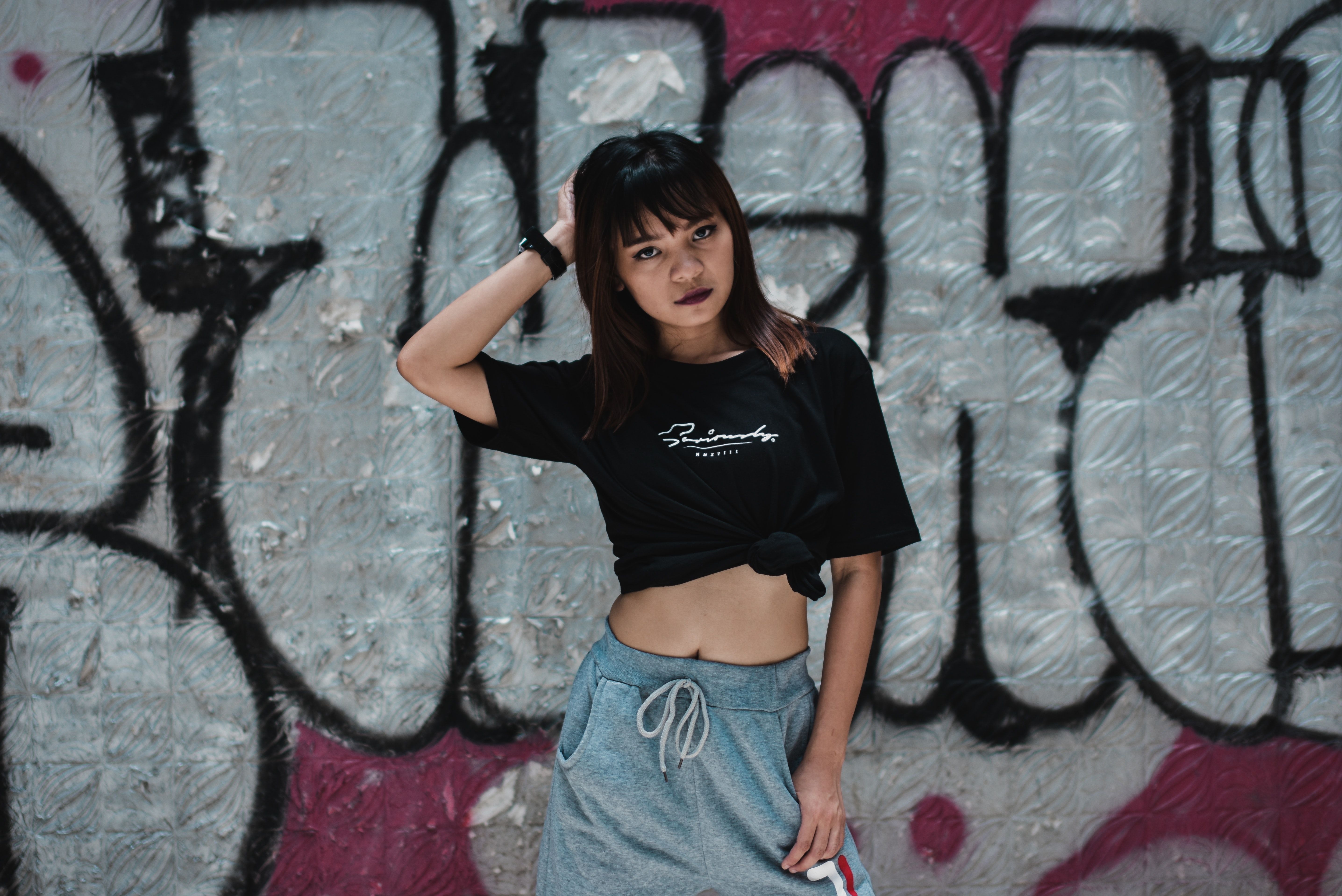 Photo Of Woman In Black T Shirt Posing In Front Of Graffiti Wall · Free