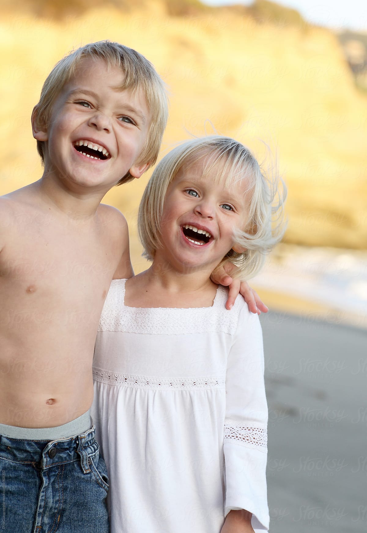 Blonde Boy And Girl Laughing On Beach by Dina Marie Giangregorio