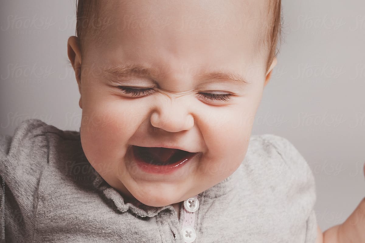 Cute Baby Girl Laughing On Solid Background by Rob And Julia Campbell