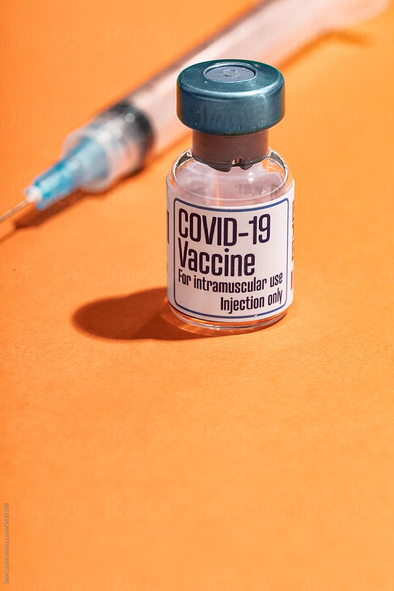 Covid 19 Vaccine Vial With Syringe On Orange Background By Sean Locke, Covid 19