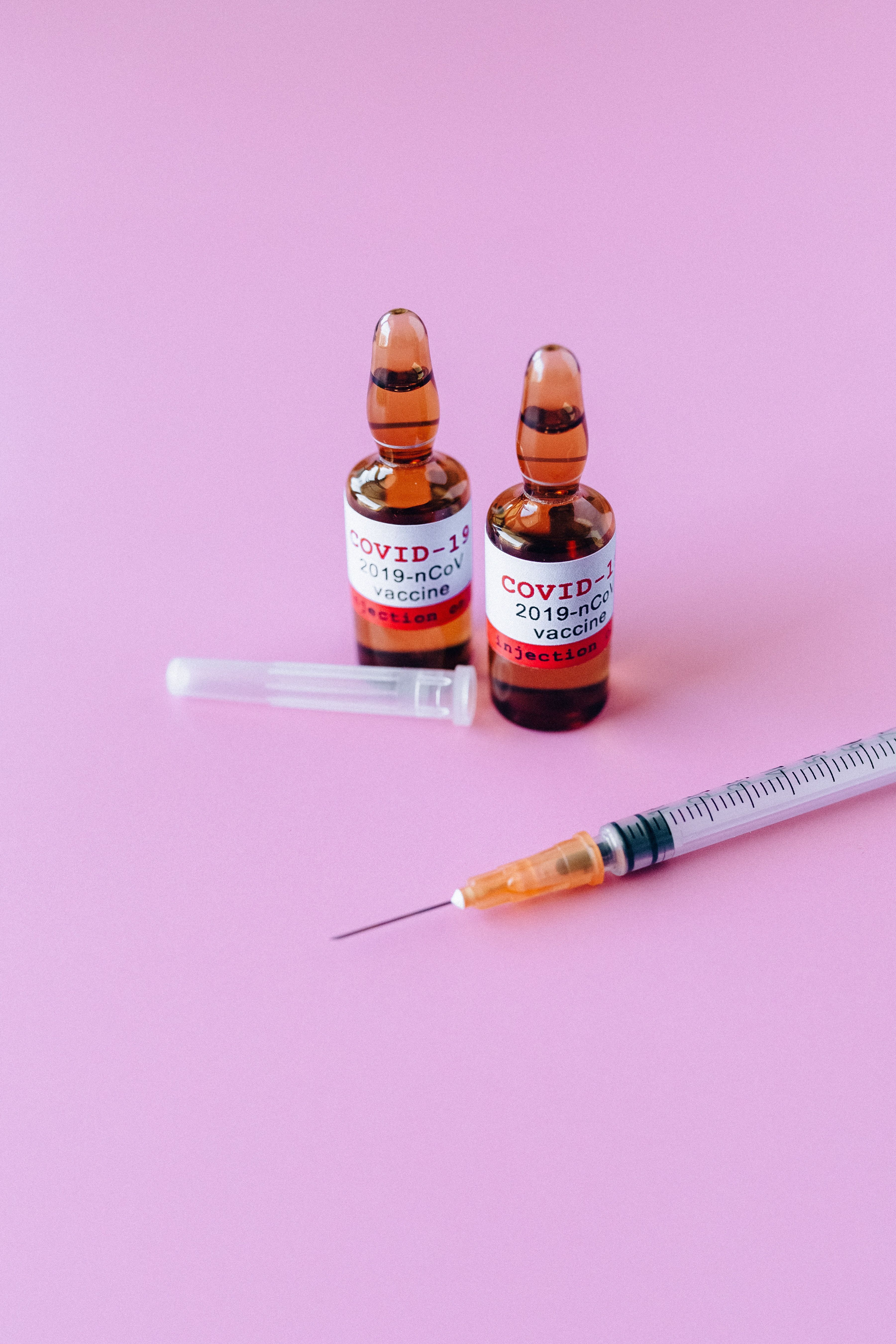 Two Vials Of Covid 19 Vaccine On Purple Background · Free