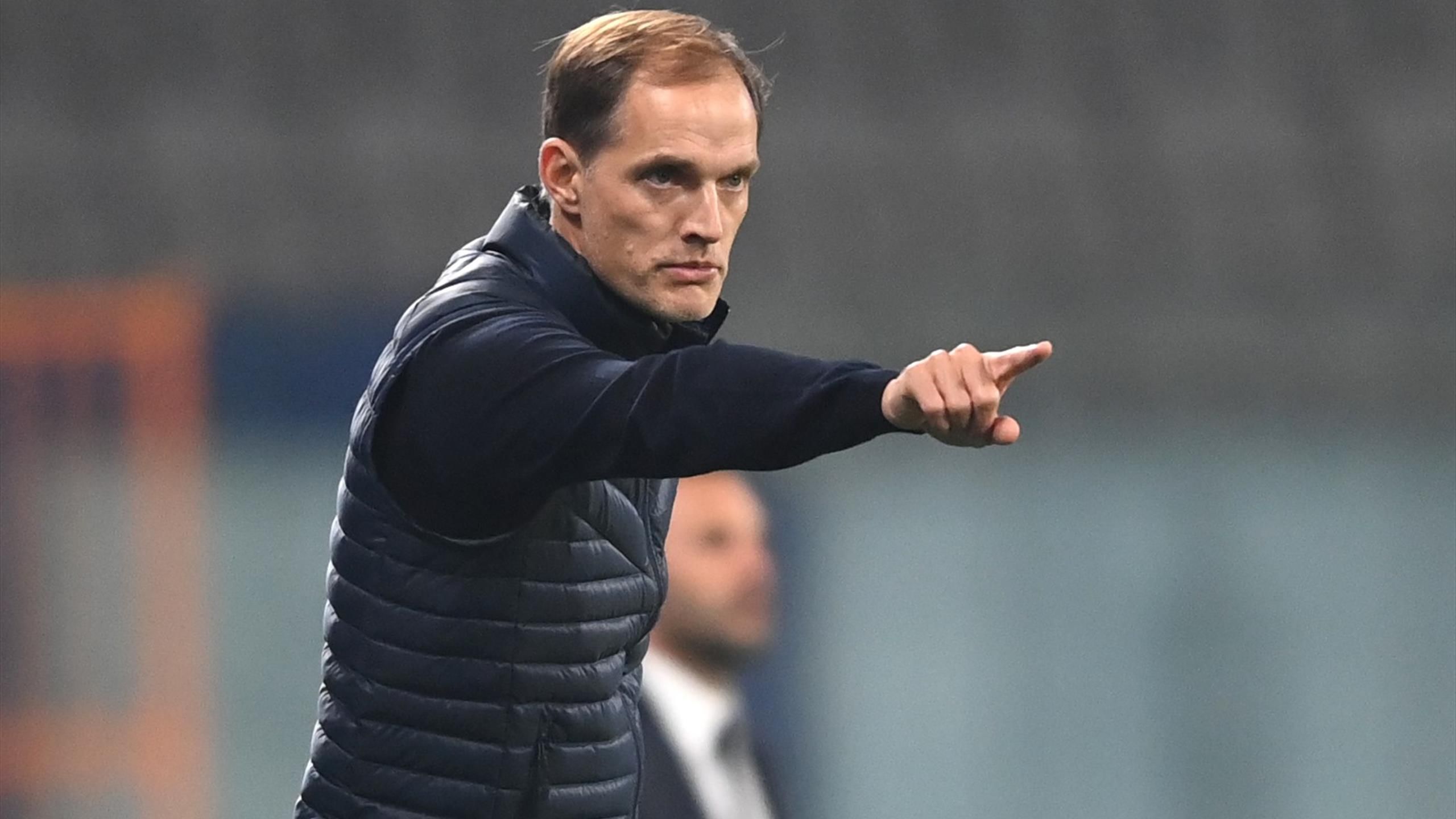  A photo of Thomas Tuchel in a suit, gesturing with his right hand.