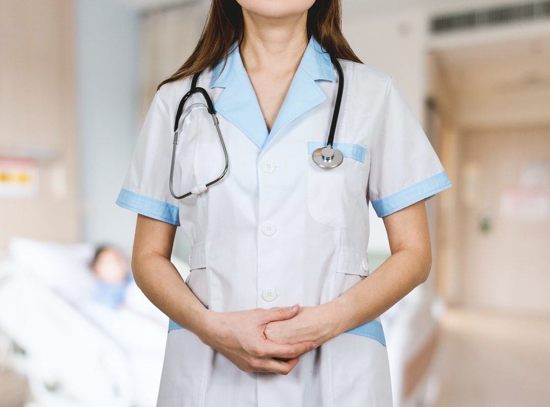 woman in white button up shirt and blue stethoscope photo
