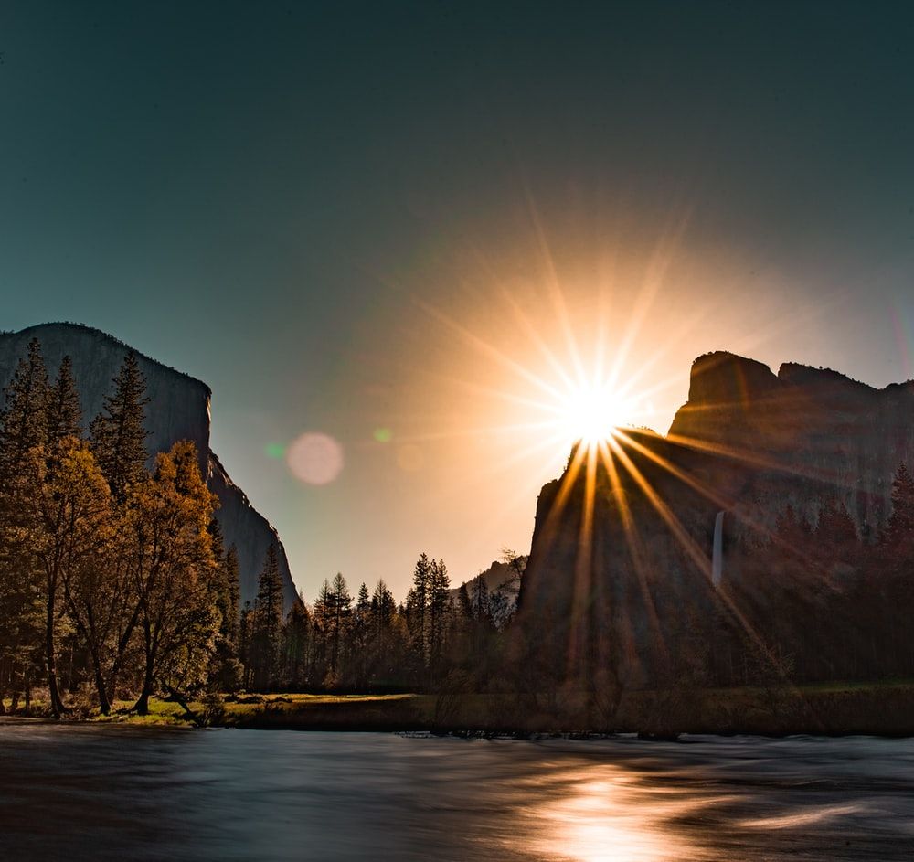 sunrise over mountains near river photo