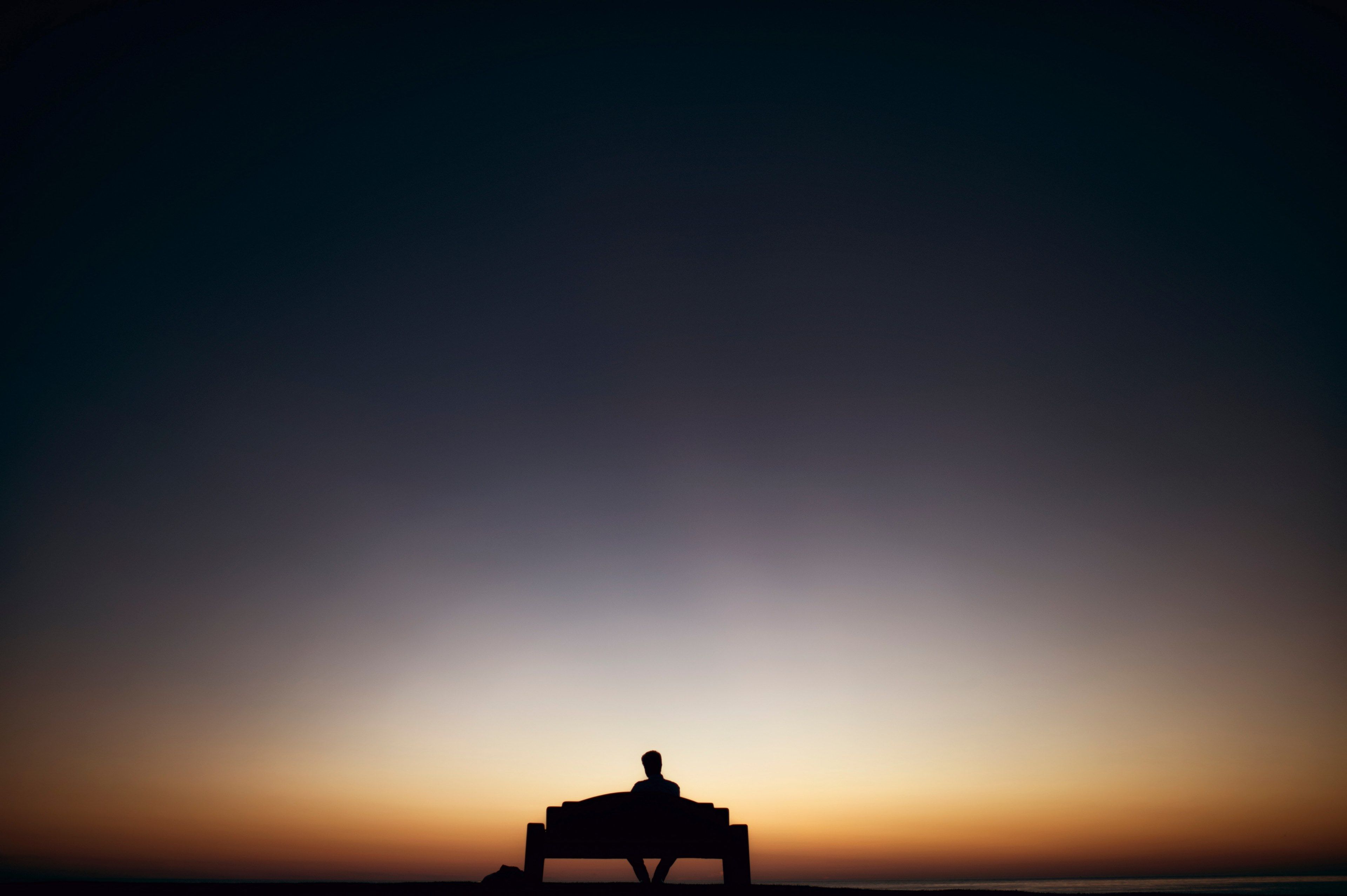 Wallpaper / sunset silhouette of a man sitting on bench alone in san diego, man sitting bench sunset 4k wallpaper