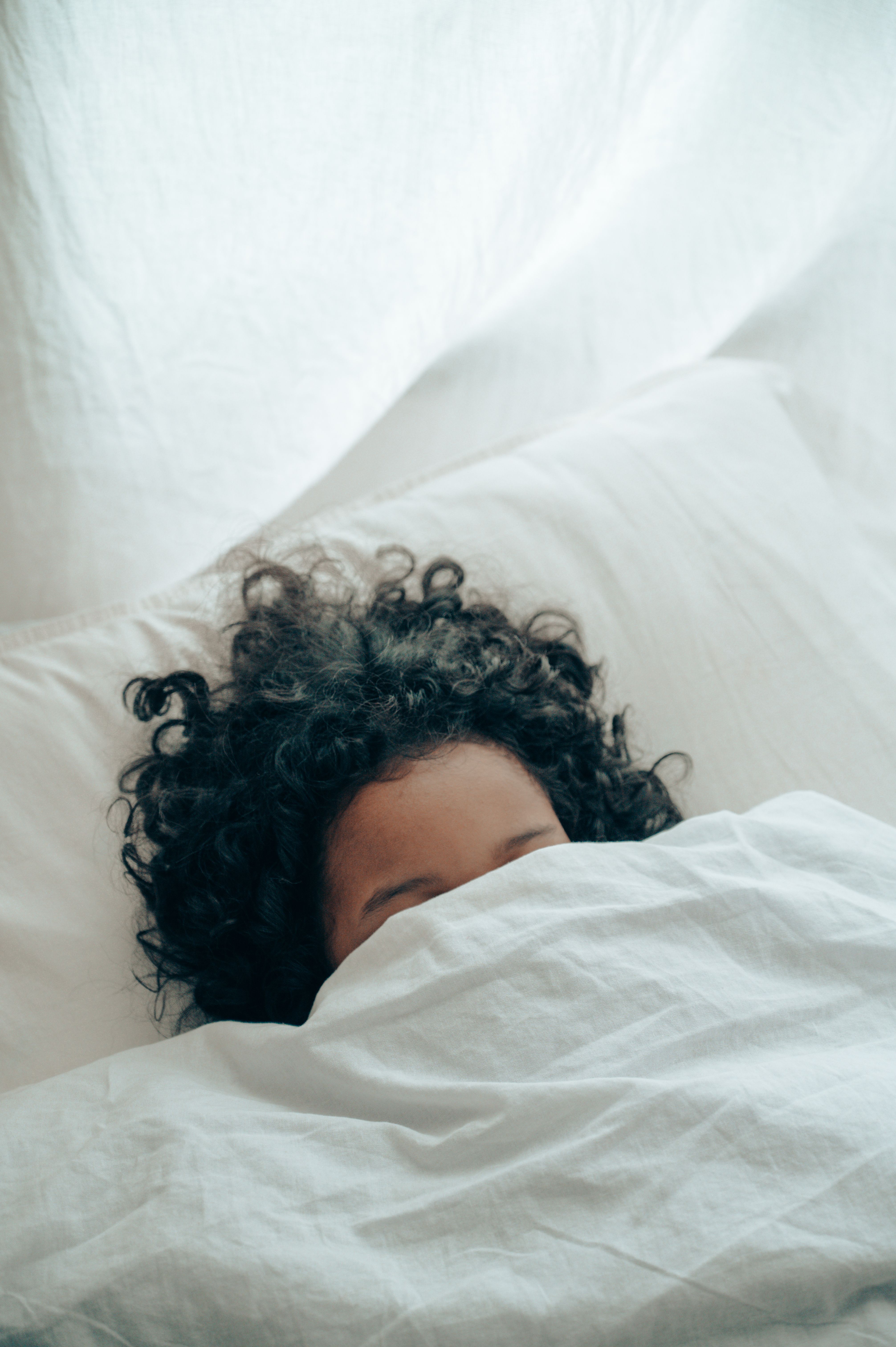 Unrecognizable person sleeping under blanket · Free