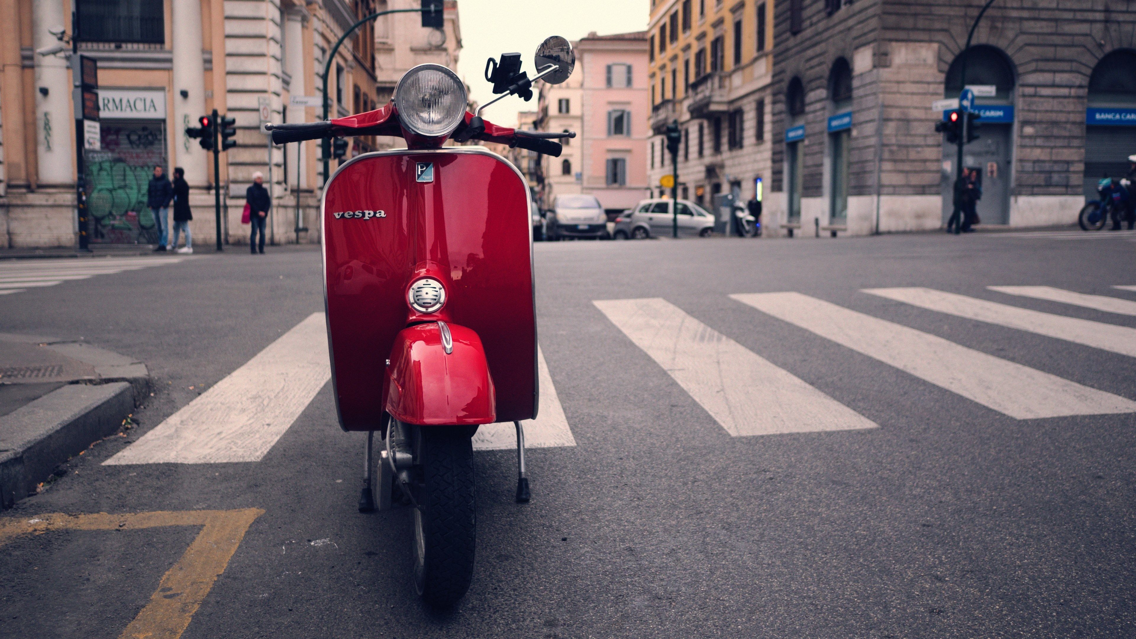 Wallpaper / red vespa scooter parked on a city street in rome, red vespa 4k wallpaper