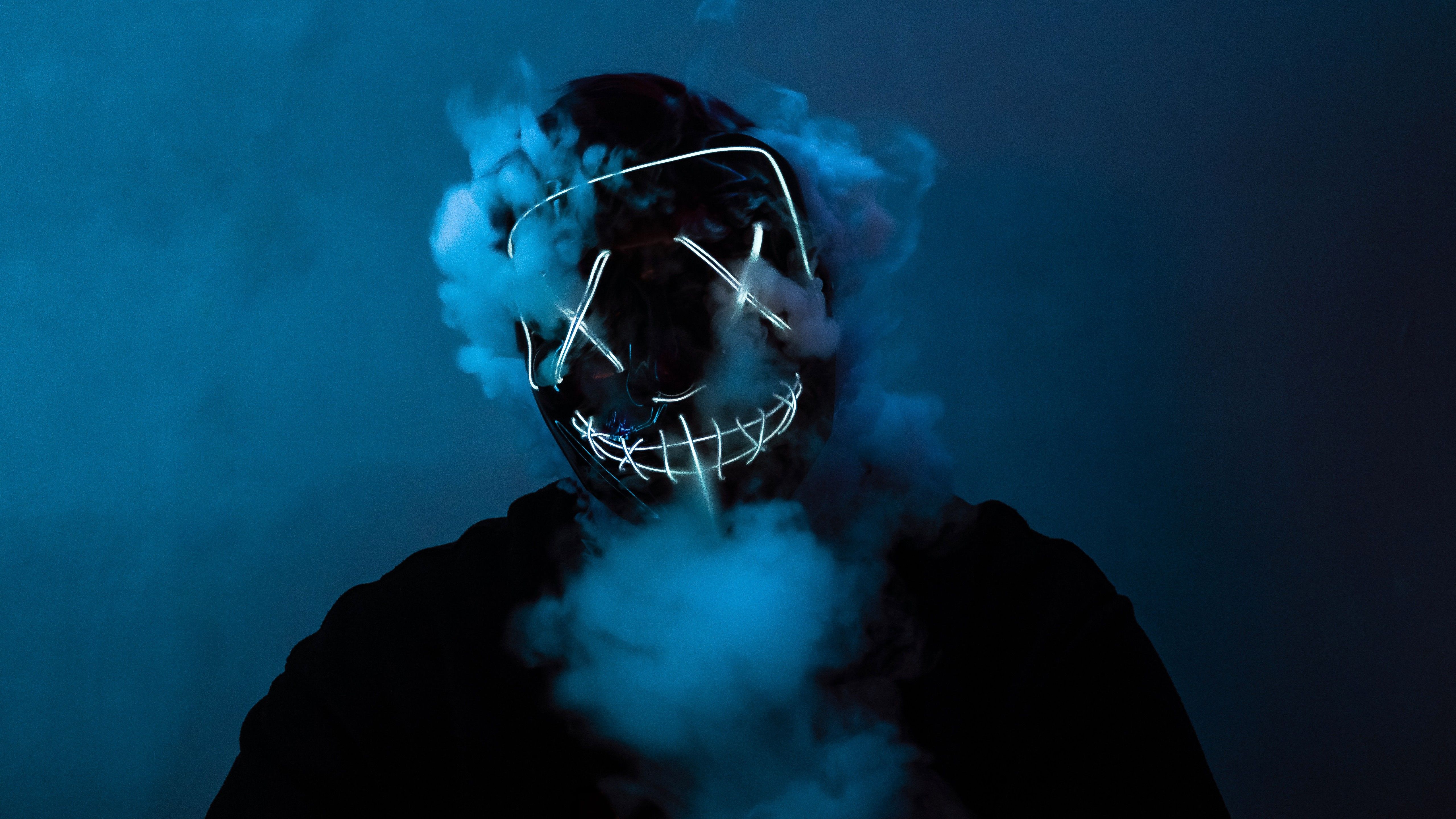 Smoke comes from under the neon mask of anonymous on the guy's face Desktop wallpapers 600x1024