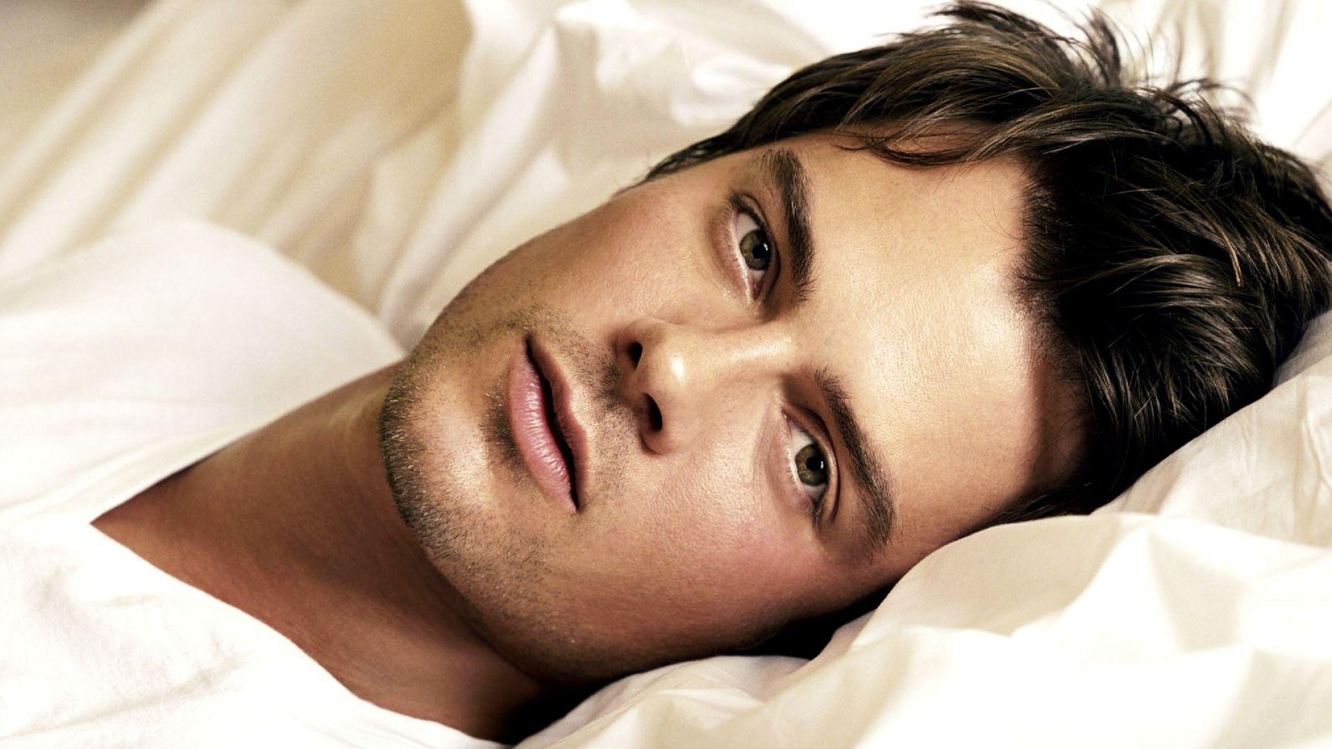 Download Wallpaper 1920x1080 josh duhamel, brunette, bed, actor, boy, black white Full HD 1080p HD Background
