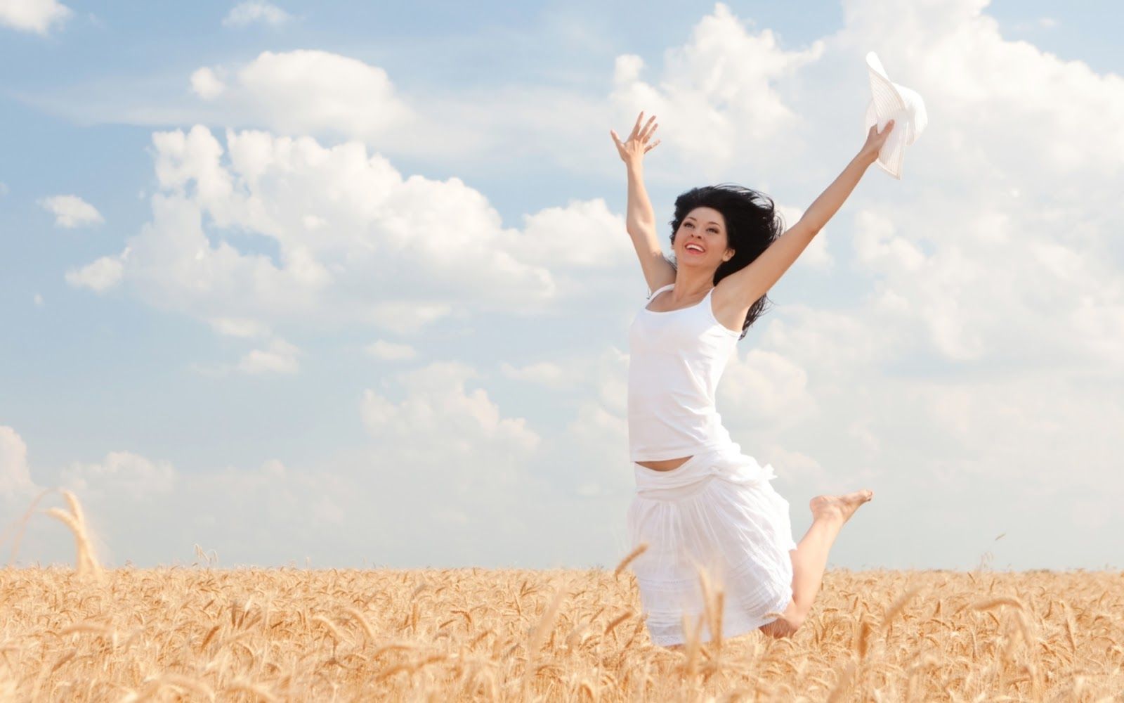 Happy Woman Jumping in Golden Wheat