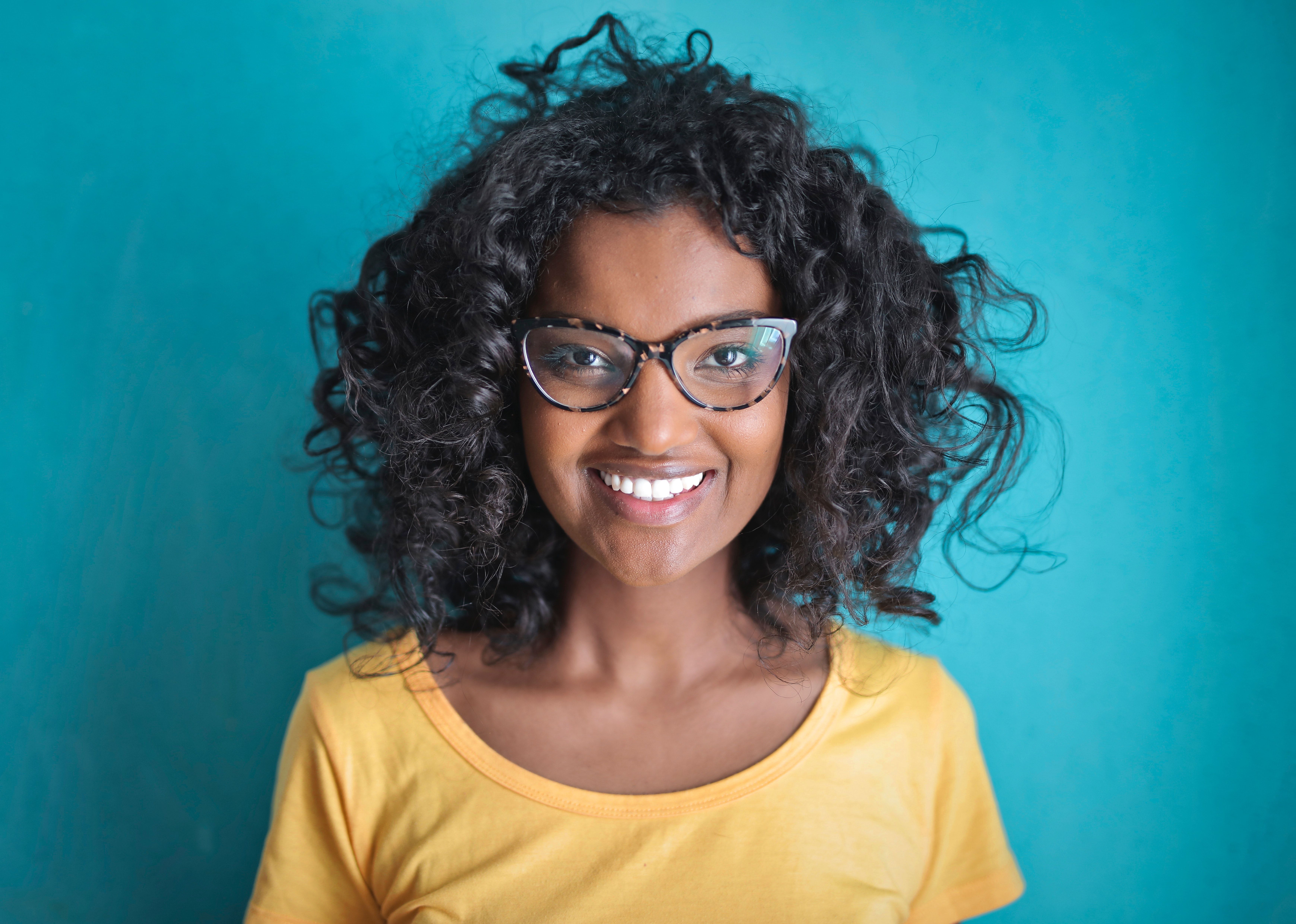 Cheerful black woman in eyeglasses smiling at camera · Free