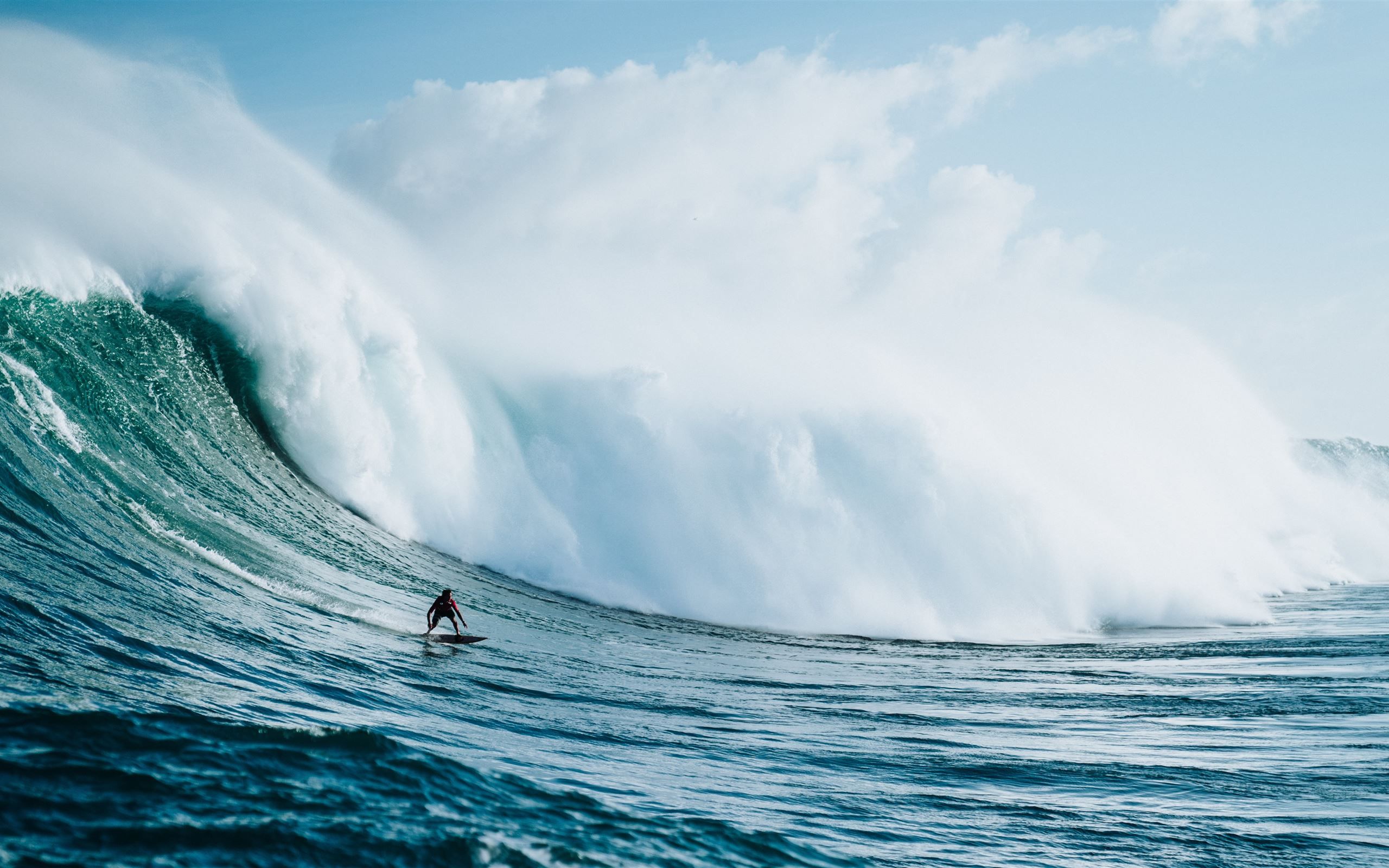 person riding on surfboard with waves behind iMac Wallpaper Download