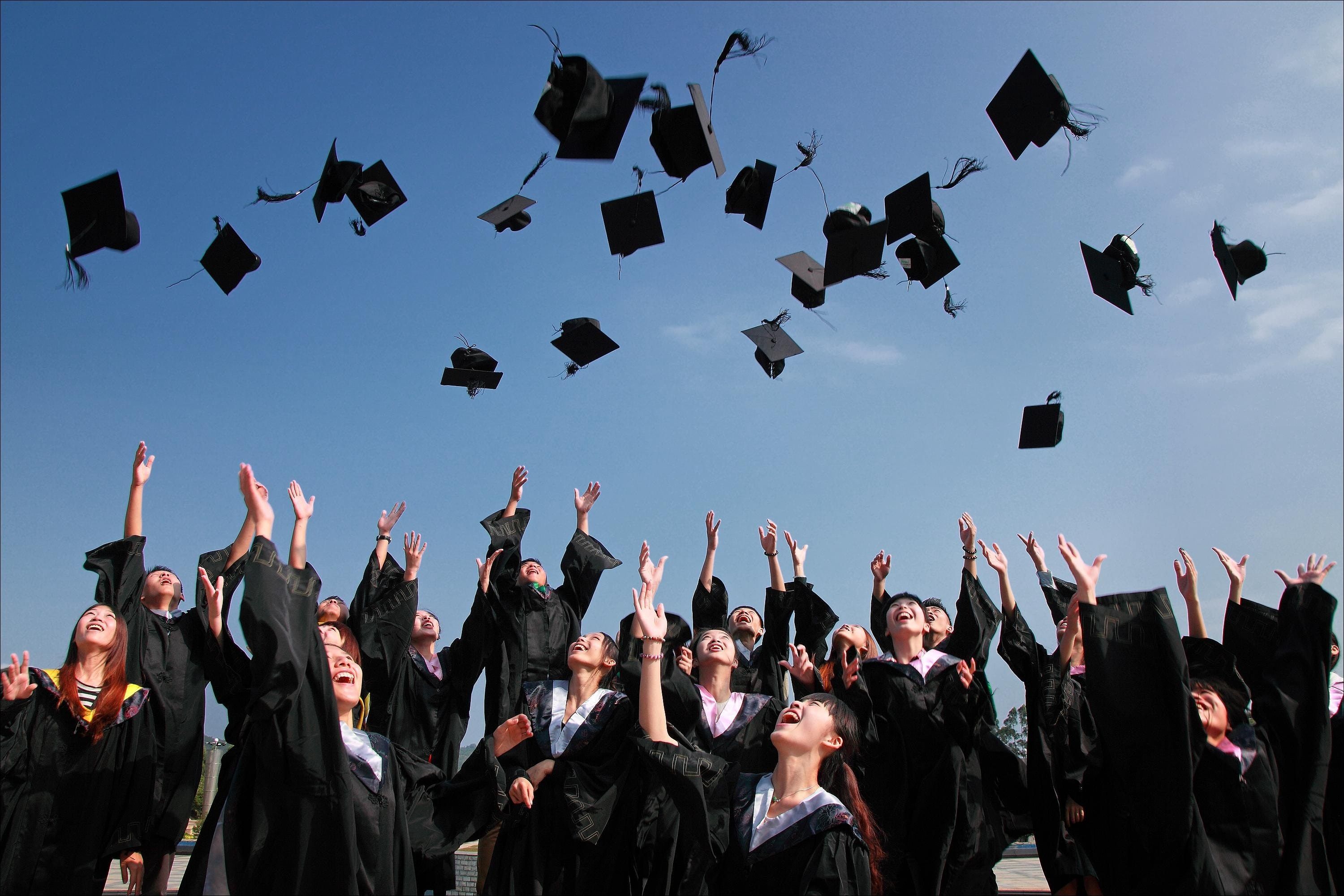 Newly Graduated People Wearing Black Academy Gowns Throwing Hats Up in the Air · Free
