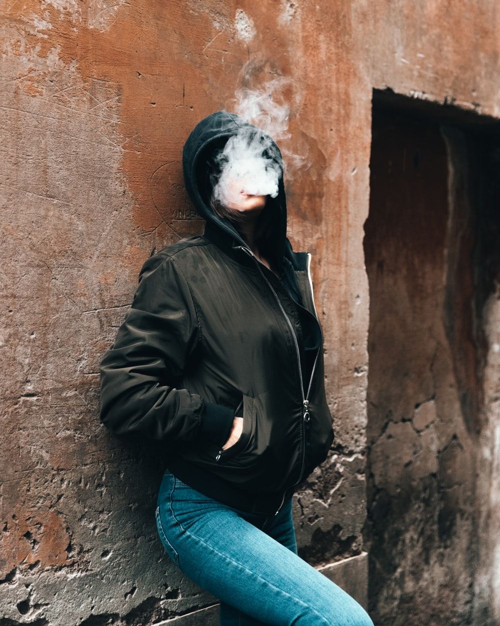 woman smoking while leaning on the wall photo