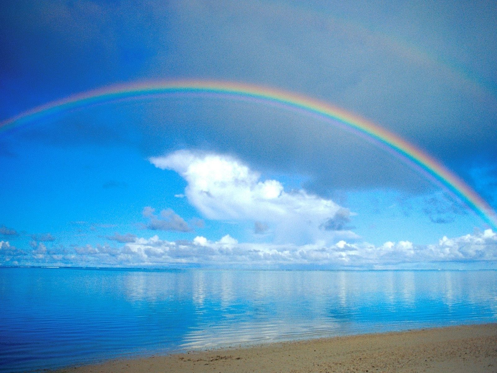 Beautiful rainbow over the blue ocean water
