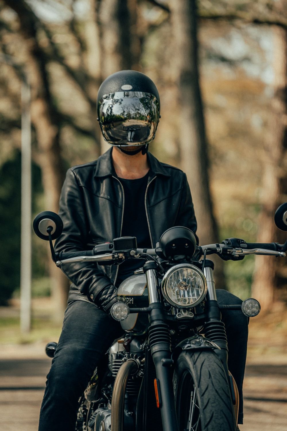 man in black leather jacket riding motorcycle photo