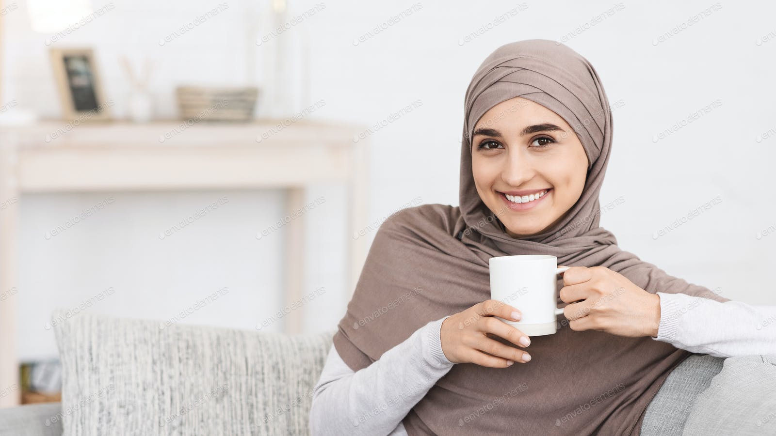 Domestic Relax. Smiling Arabic Girl In Hijab Relaxing On Couch With Coffee Photo By Prostock Studio On Envato Elements