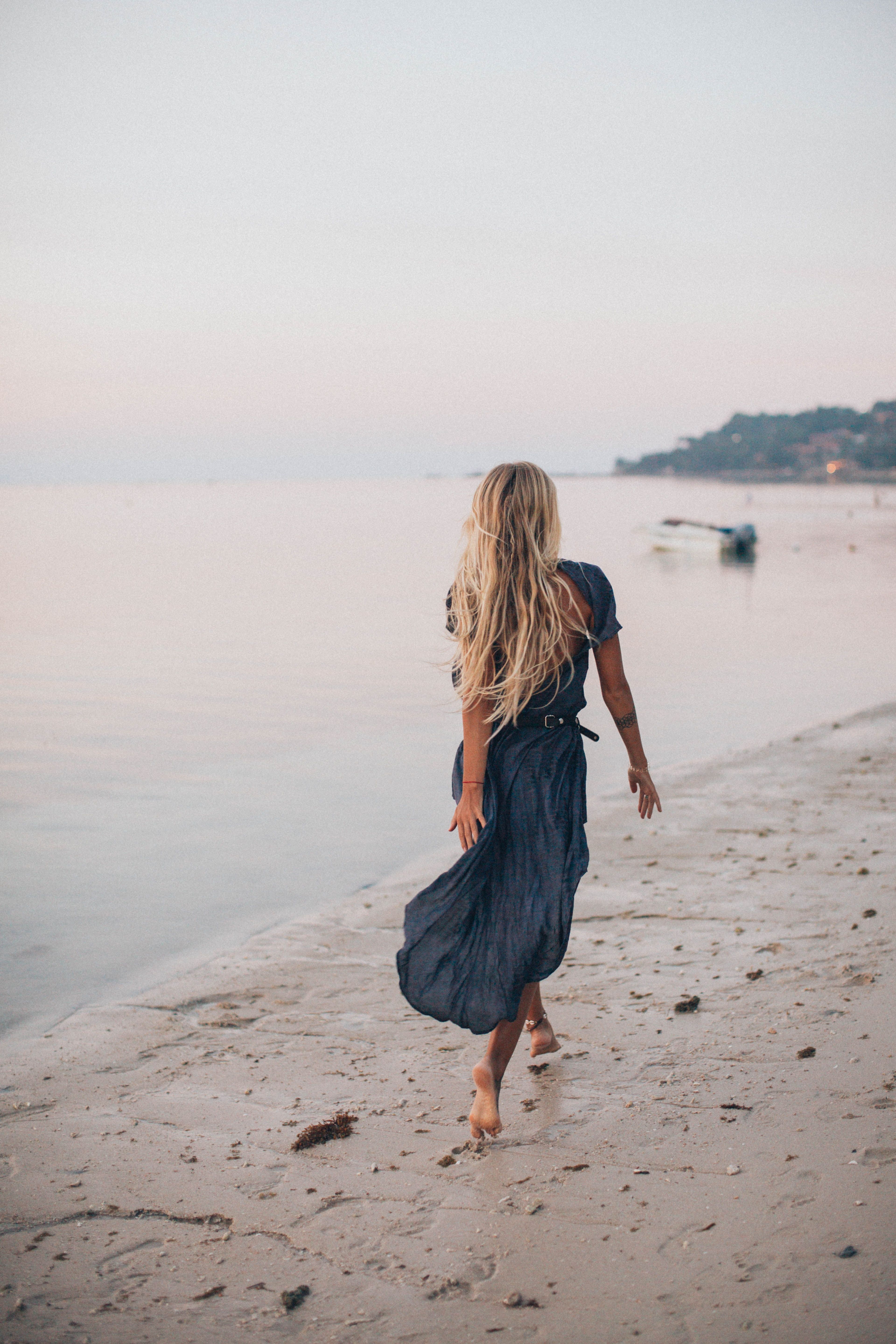 Photo of Woman Walking On Seashore · Free