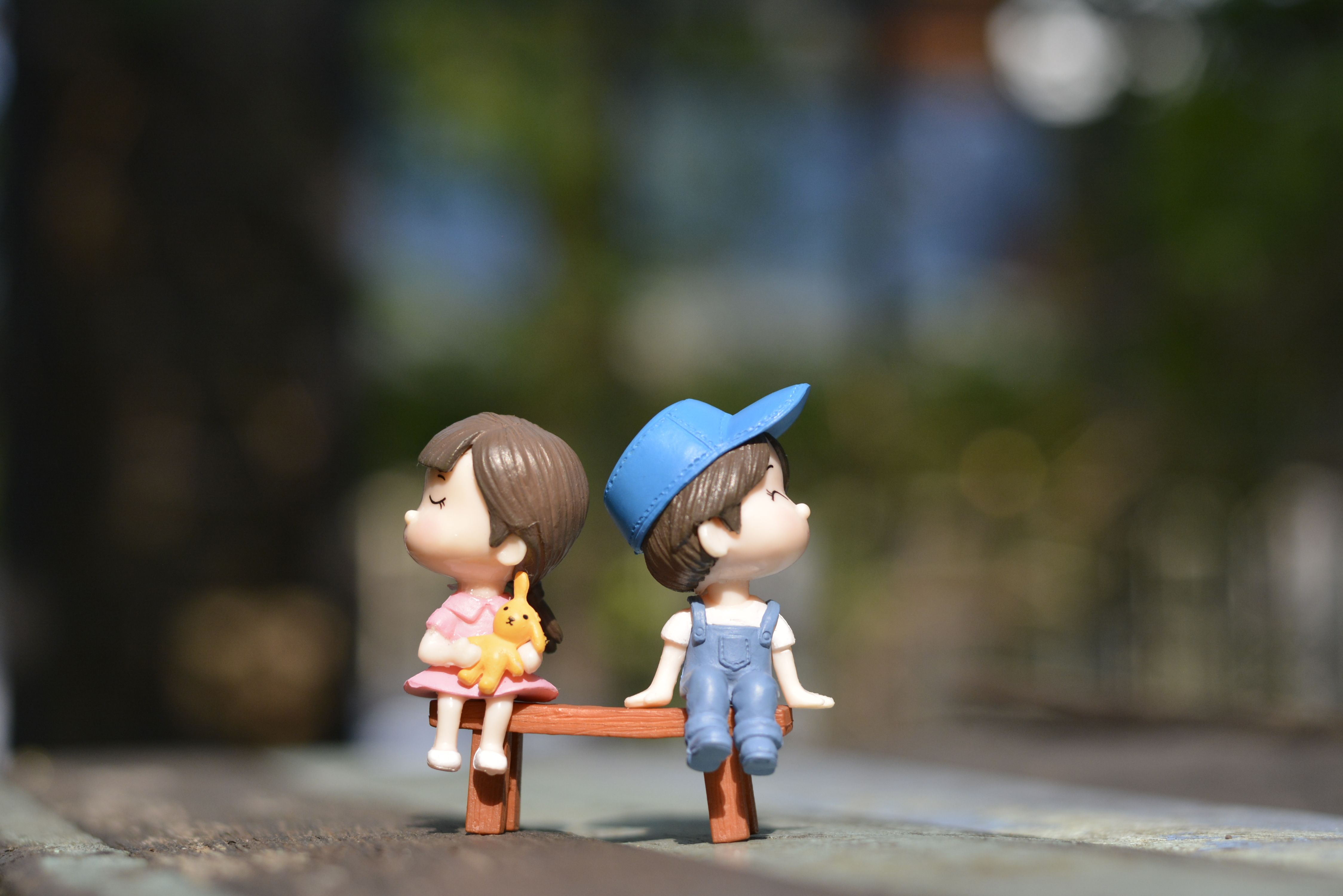 Boy and Girl Sitting on Bench Toy · Free