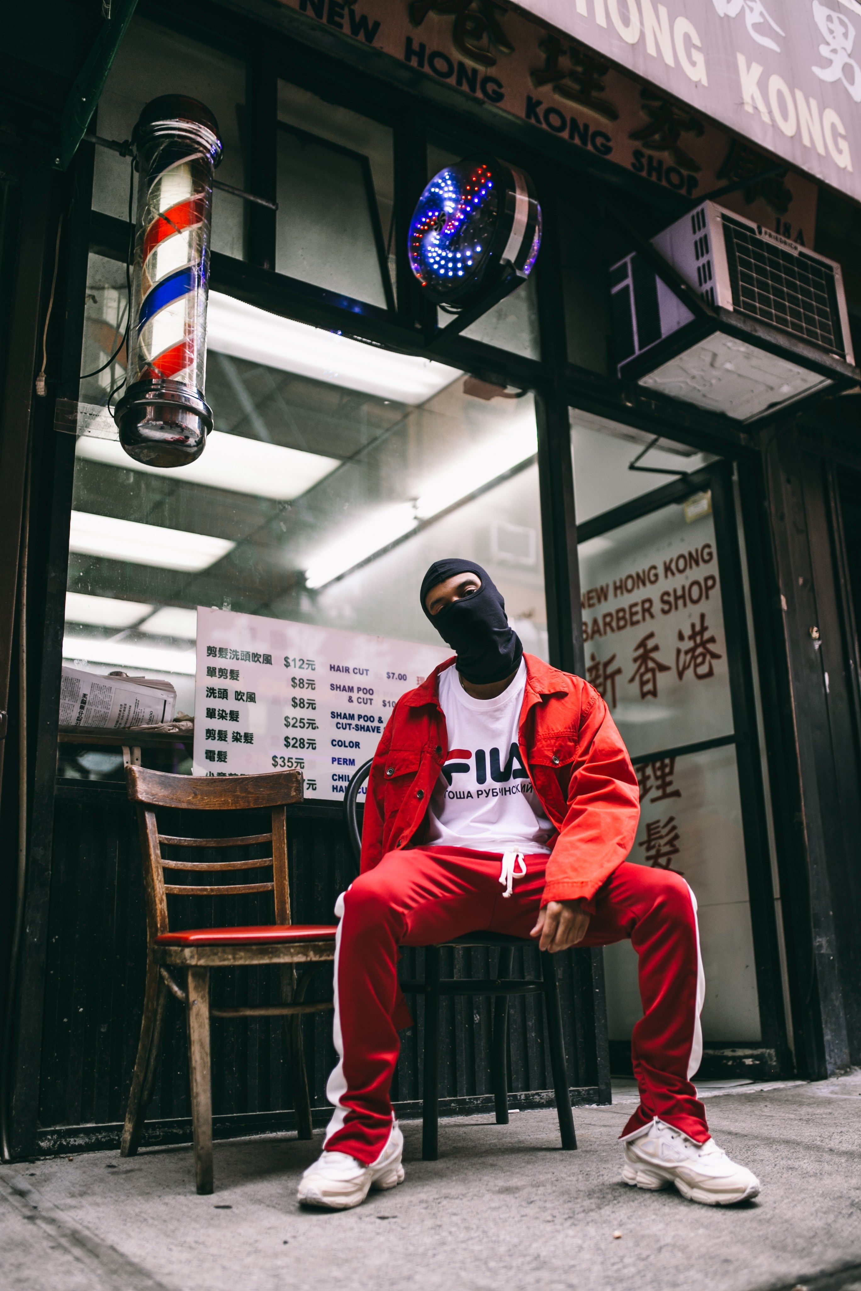 Wallpaper / a nan in a balaclava and fila sportswear sits in front of an old barbershop, _code red 4k wallpaper