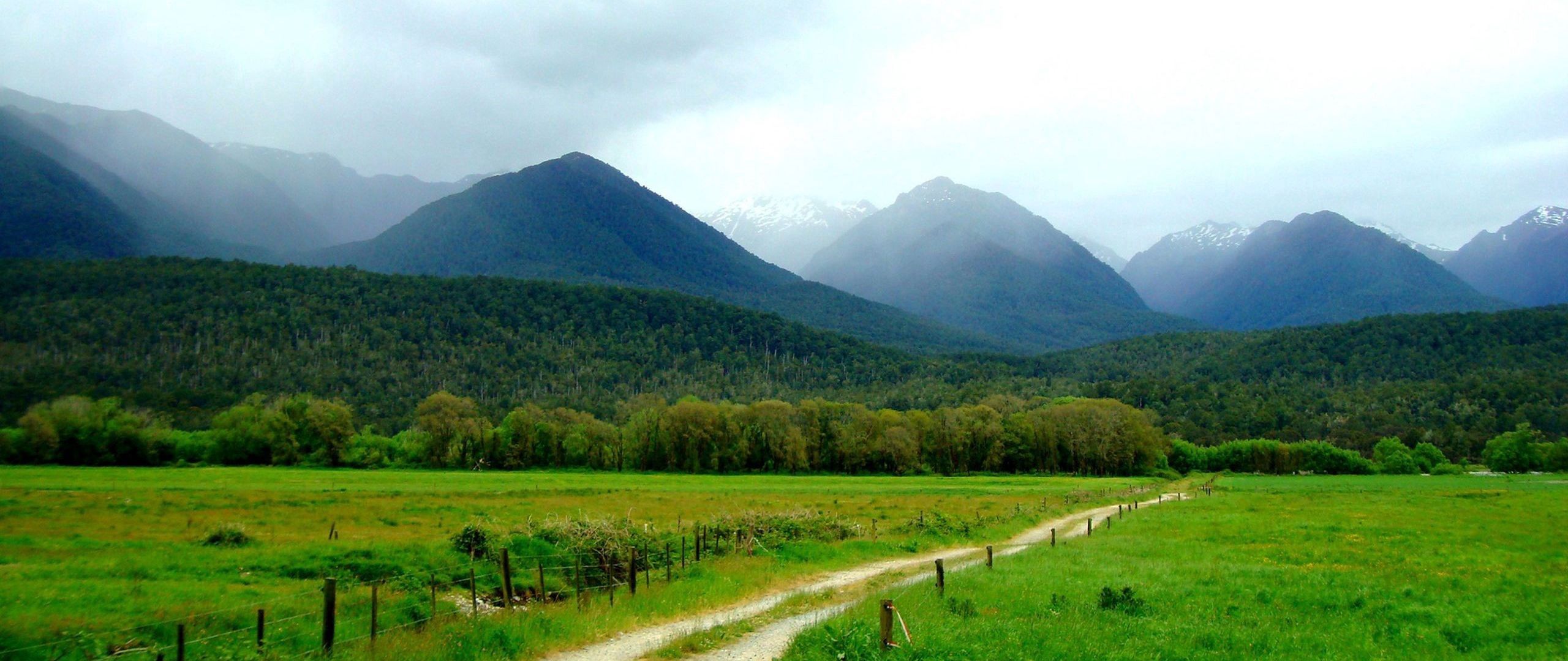Download wallpaper 2560x1080 mountains, grass, summer, fence dual wide 1080p HD background