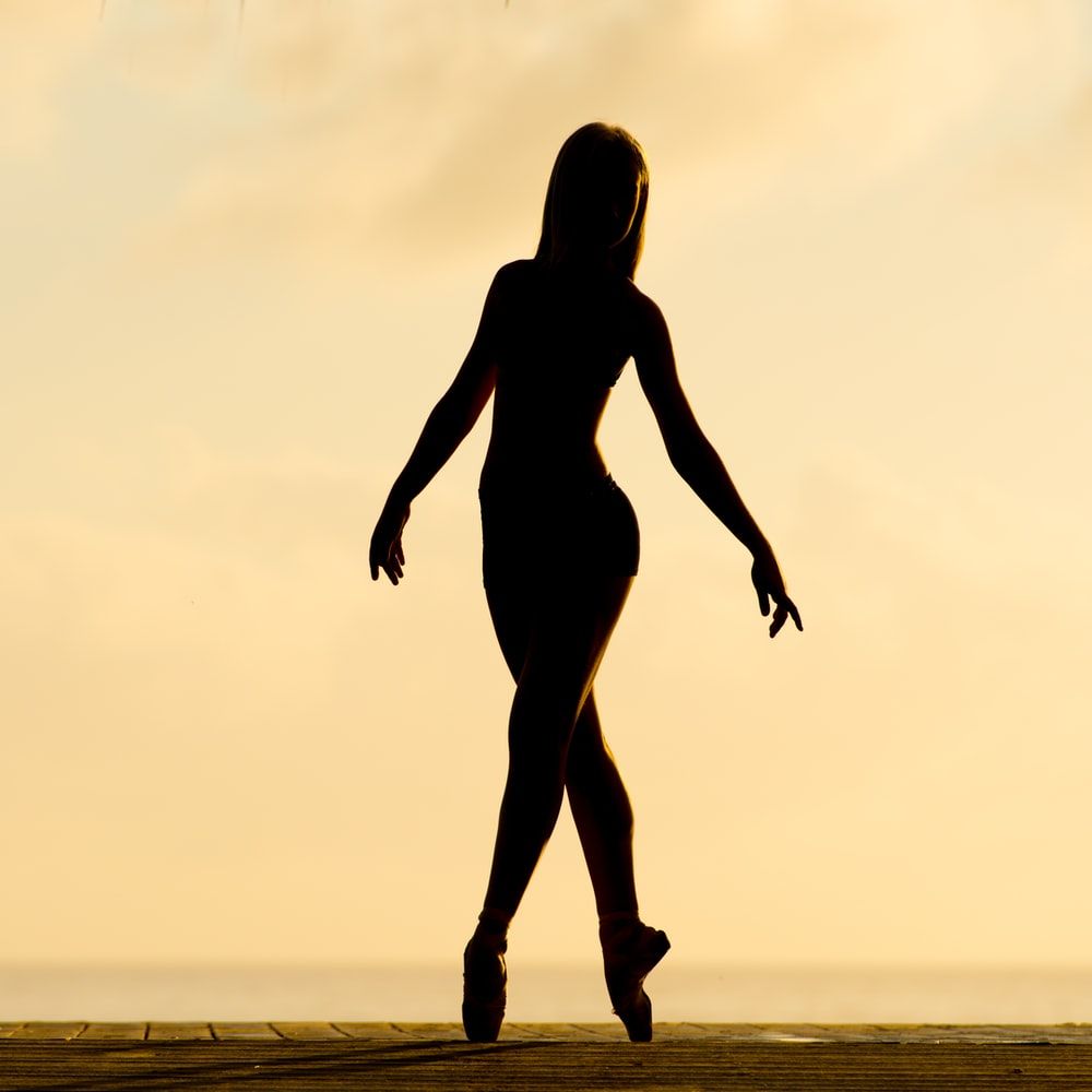 silhouette of woman performing ballet photo