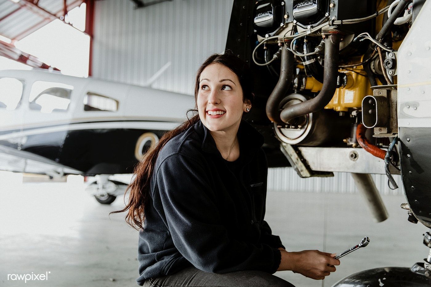 Download premium image of Female aviation technician repairing the motor. Aviation, Aviation mechanic, Female
