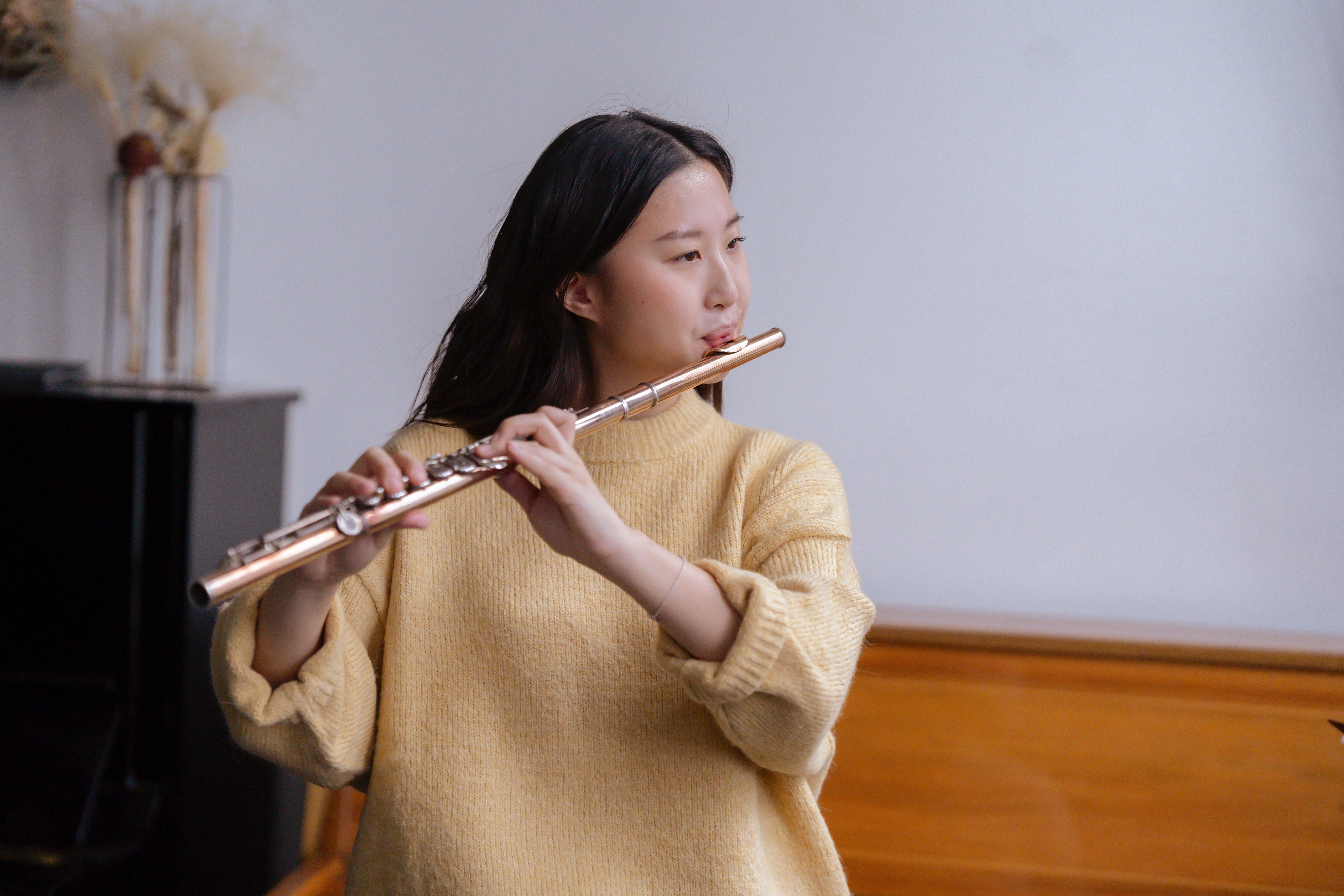 Skilled Asian woman playing flute · Free