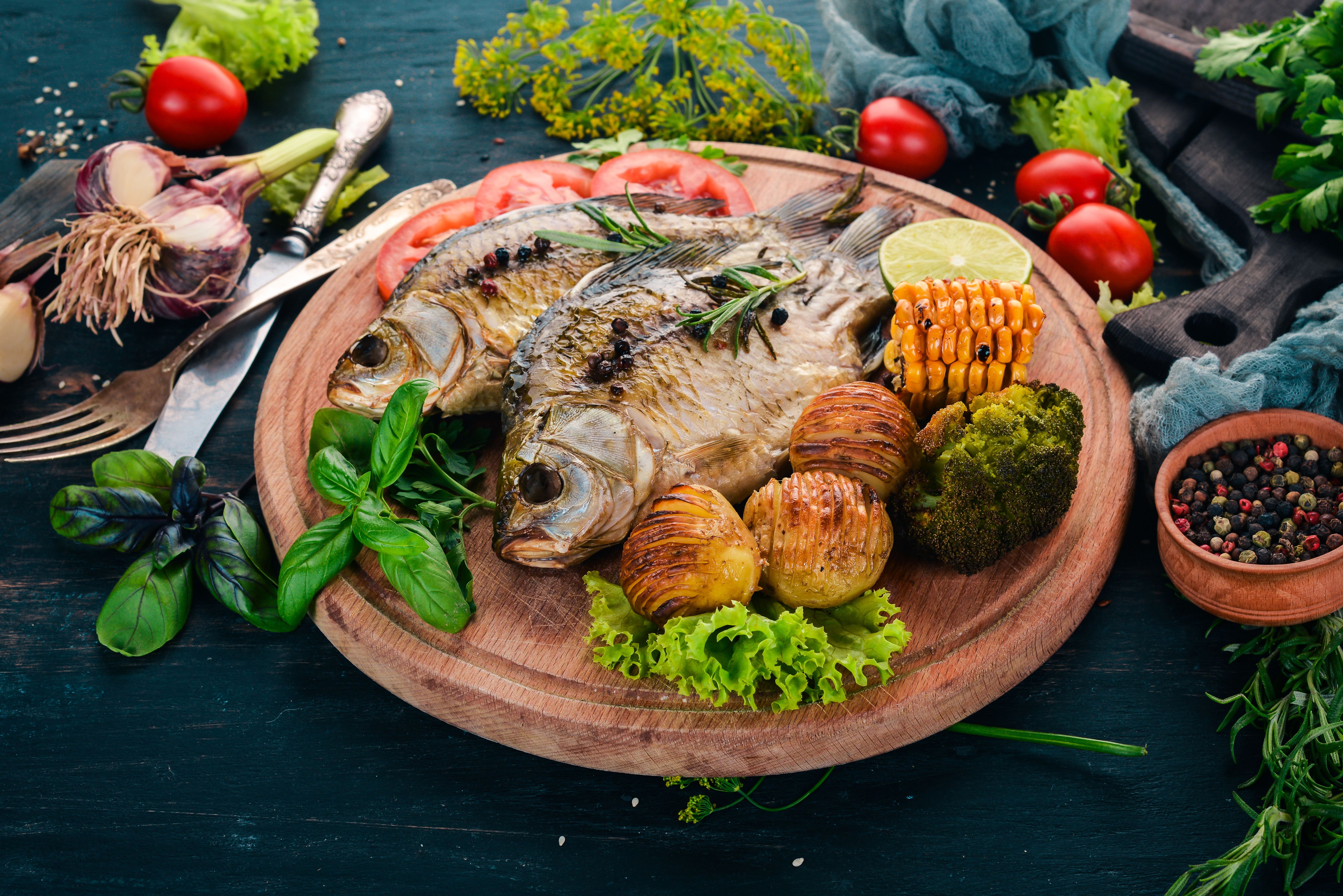Grilled fish on a board with vegetables wallpaper and image, picture, photo