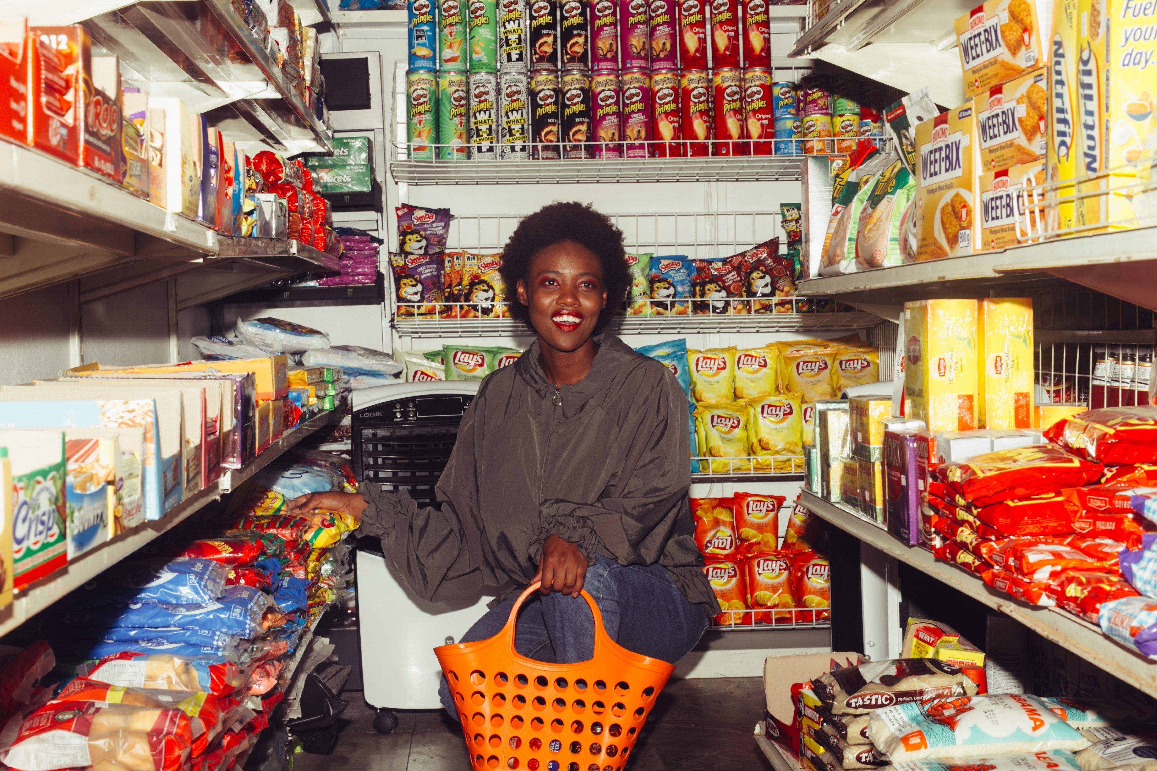 Smiling black woman choosing goods in grocery store · Free