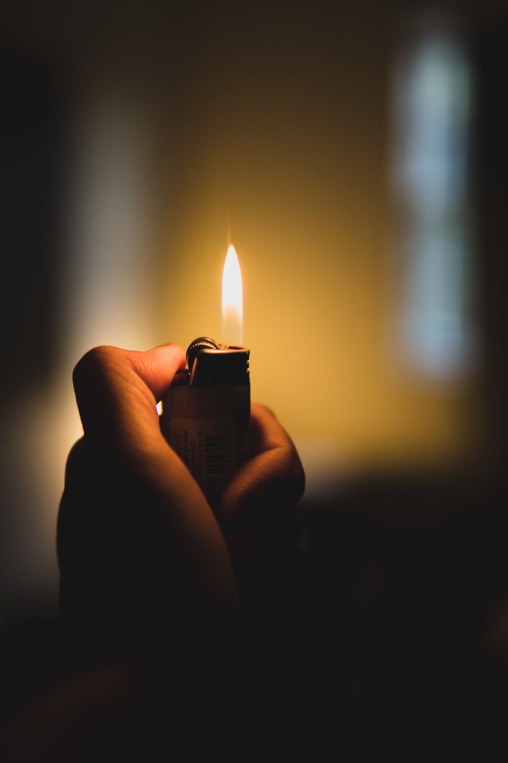 person holding lighter with yellow light photo