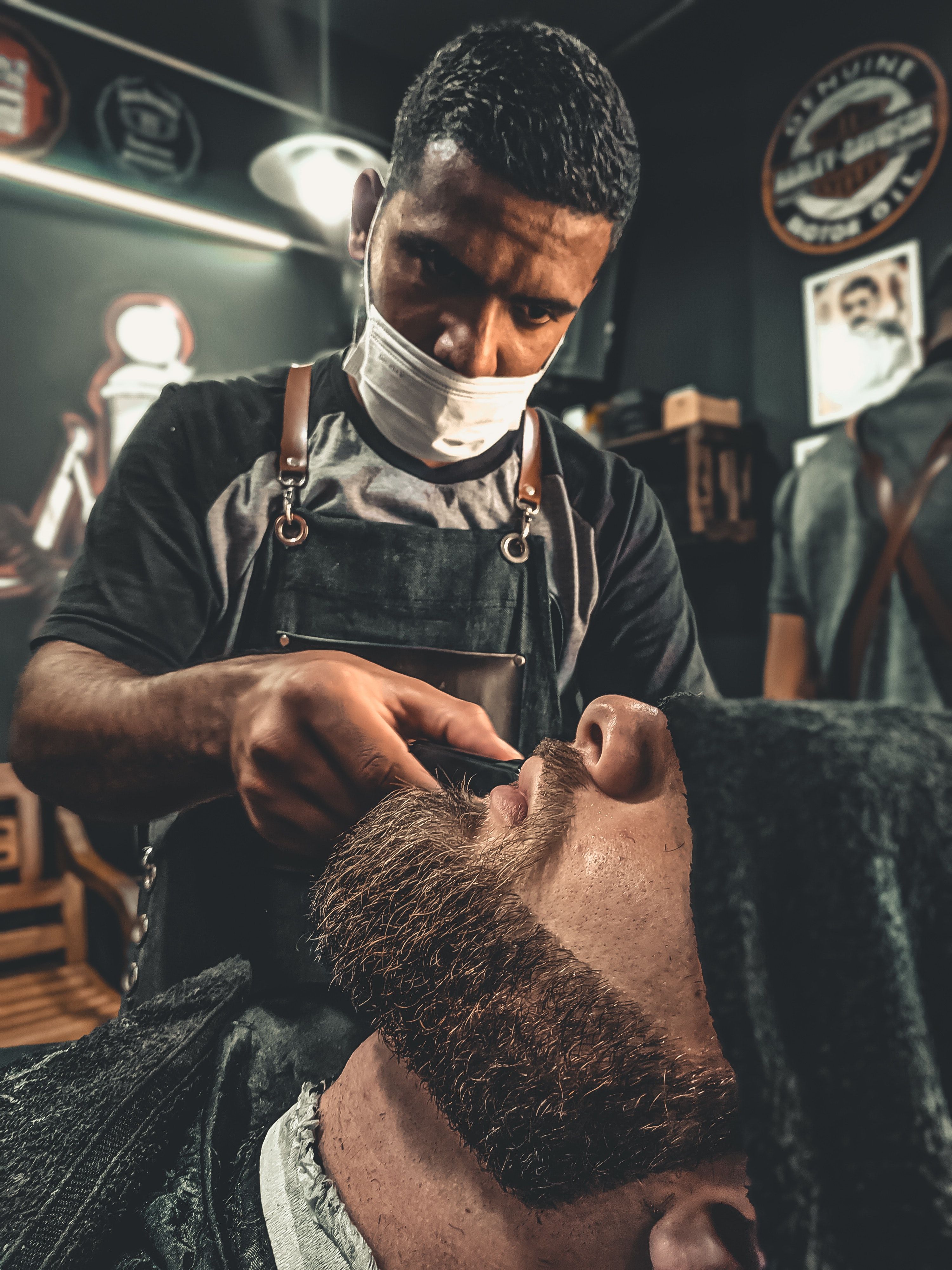 A Barber Grooming A Man's Beard · Free