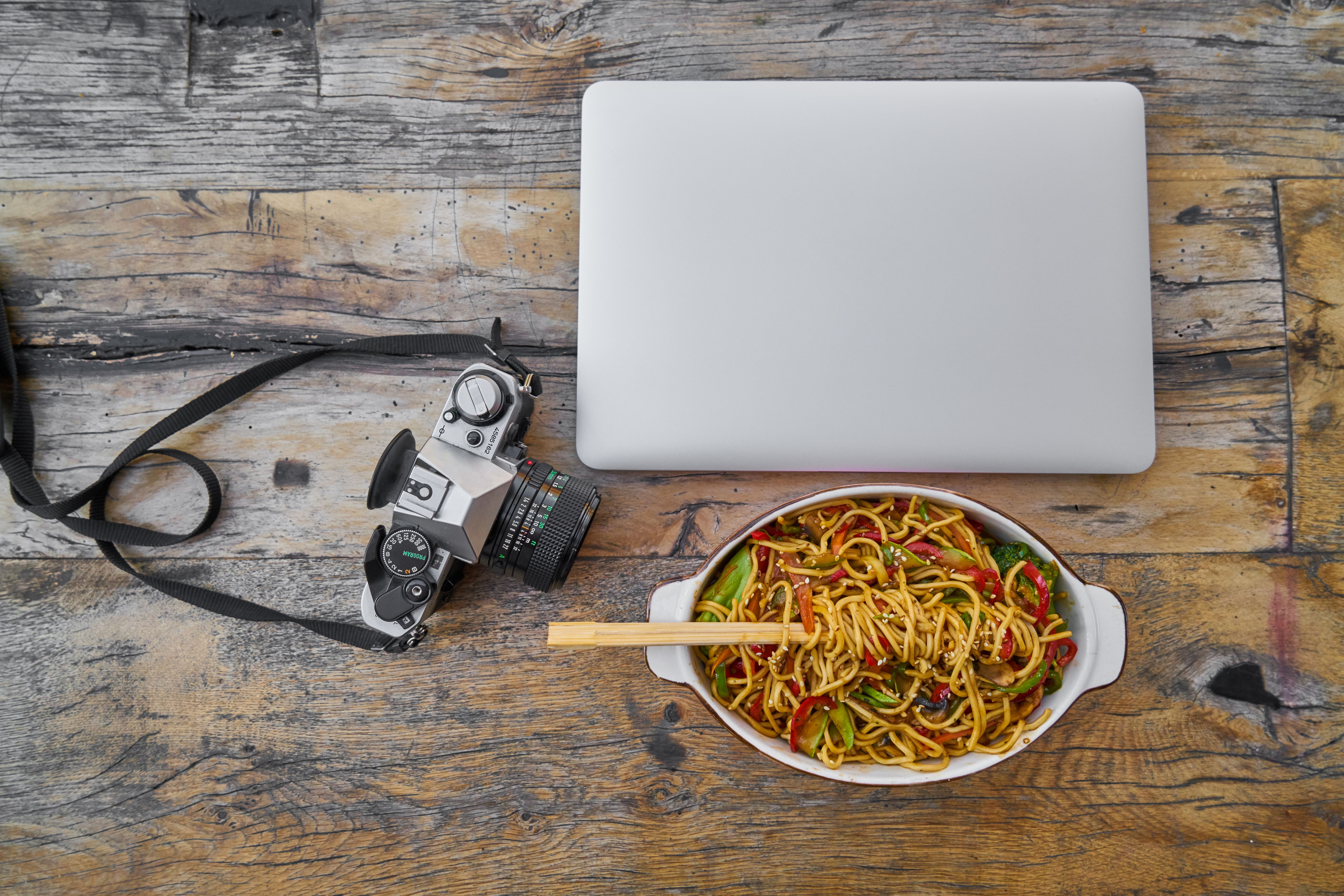 Camera Beside Laptop And Stir Fry Noodles In Bowl On Table · Free