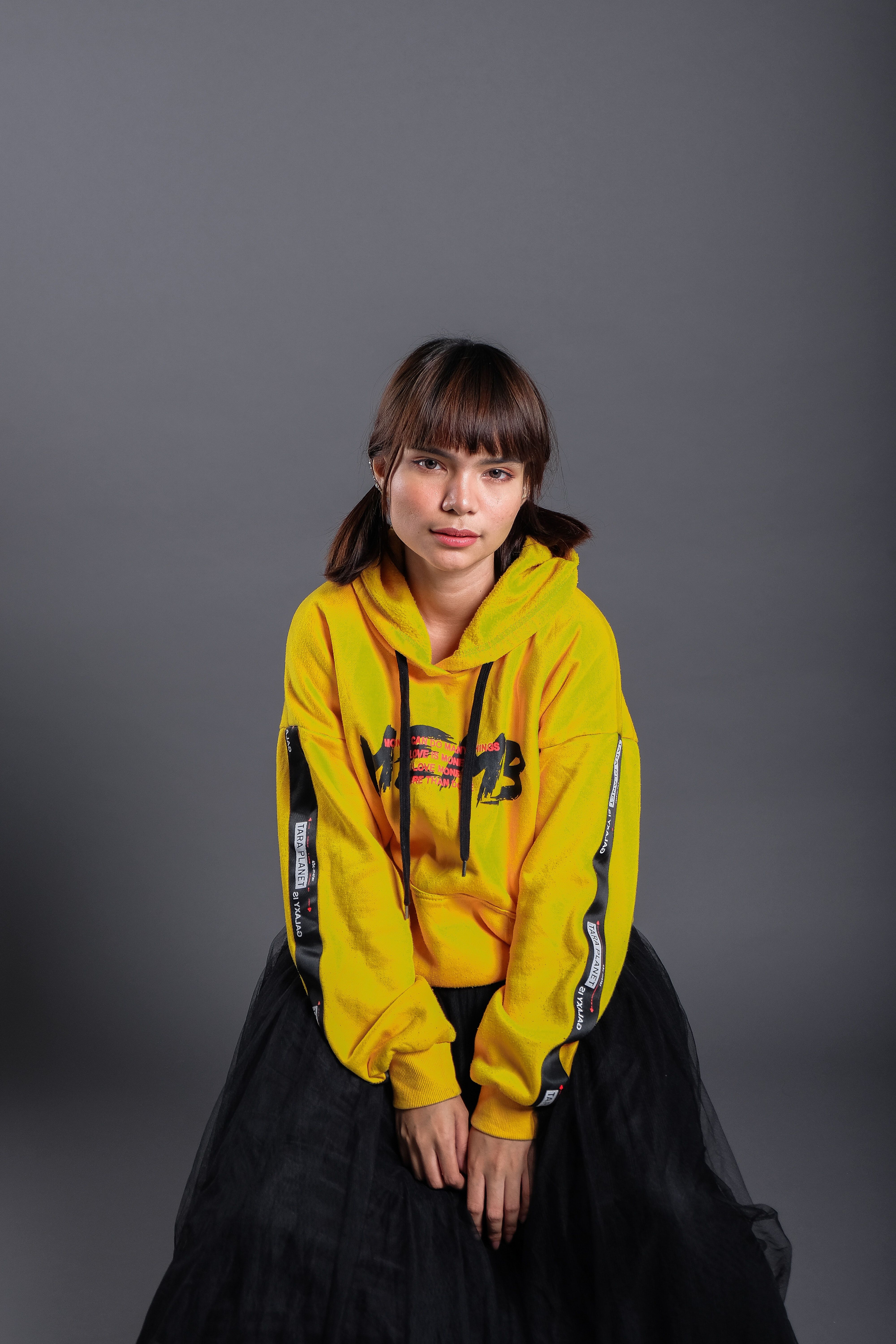 Sitting Woman Wearing Yellow Pullover Hoodie and Black Maxi Skirt · Free