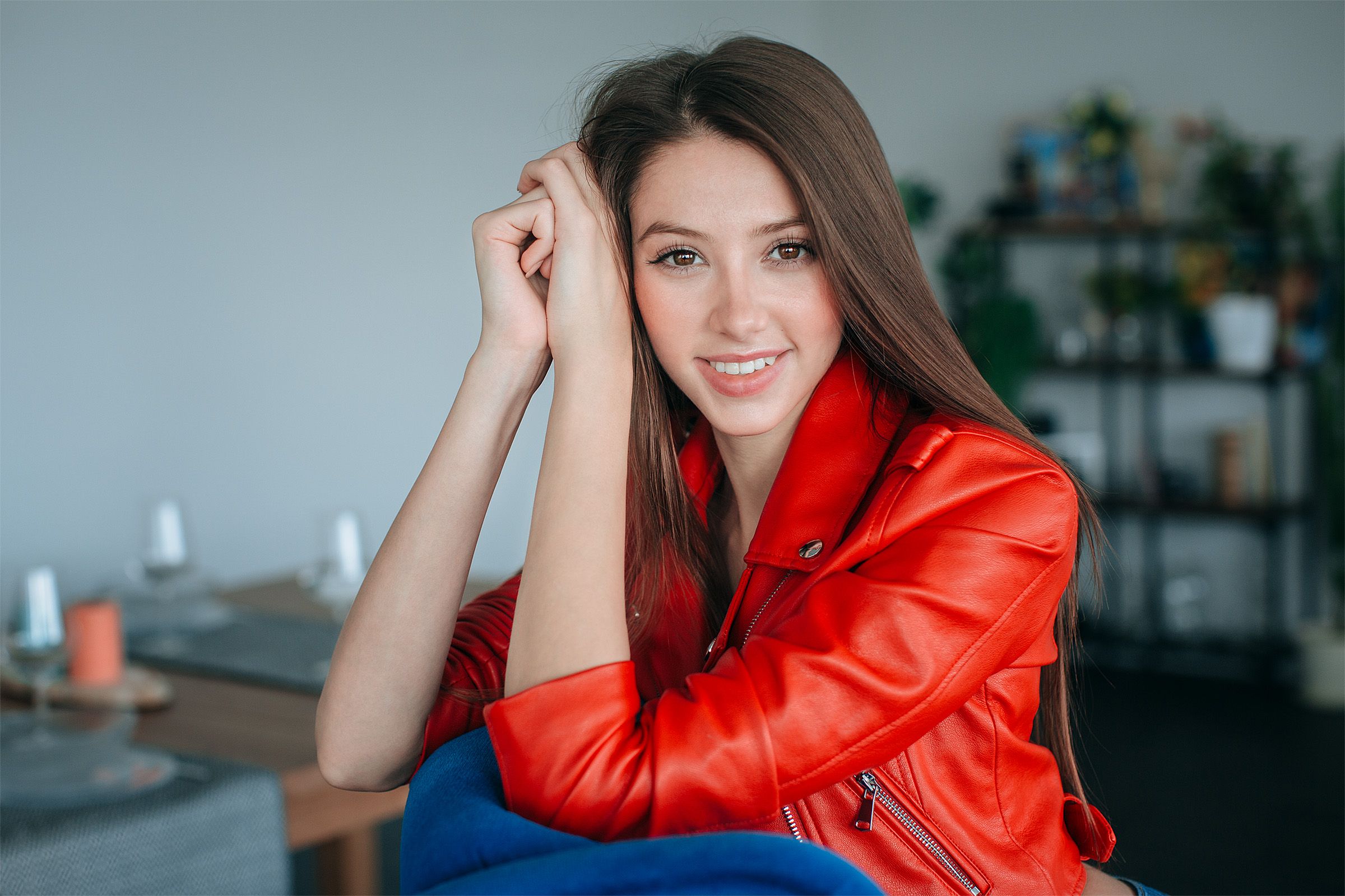 Wallpaper, model, brunette, looking at viewer, smiling, portrait, depth of field, sitting, long hair, face, jacket, leather jackets, red jackets, women indoors 2400x1600