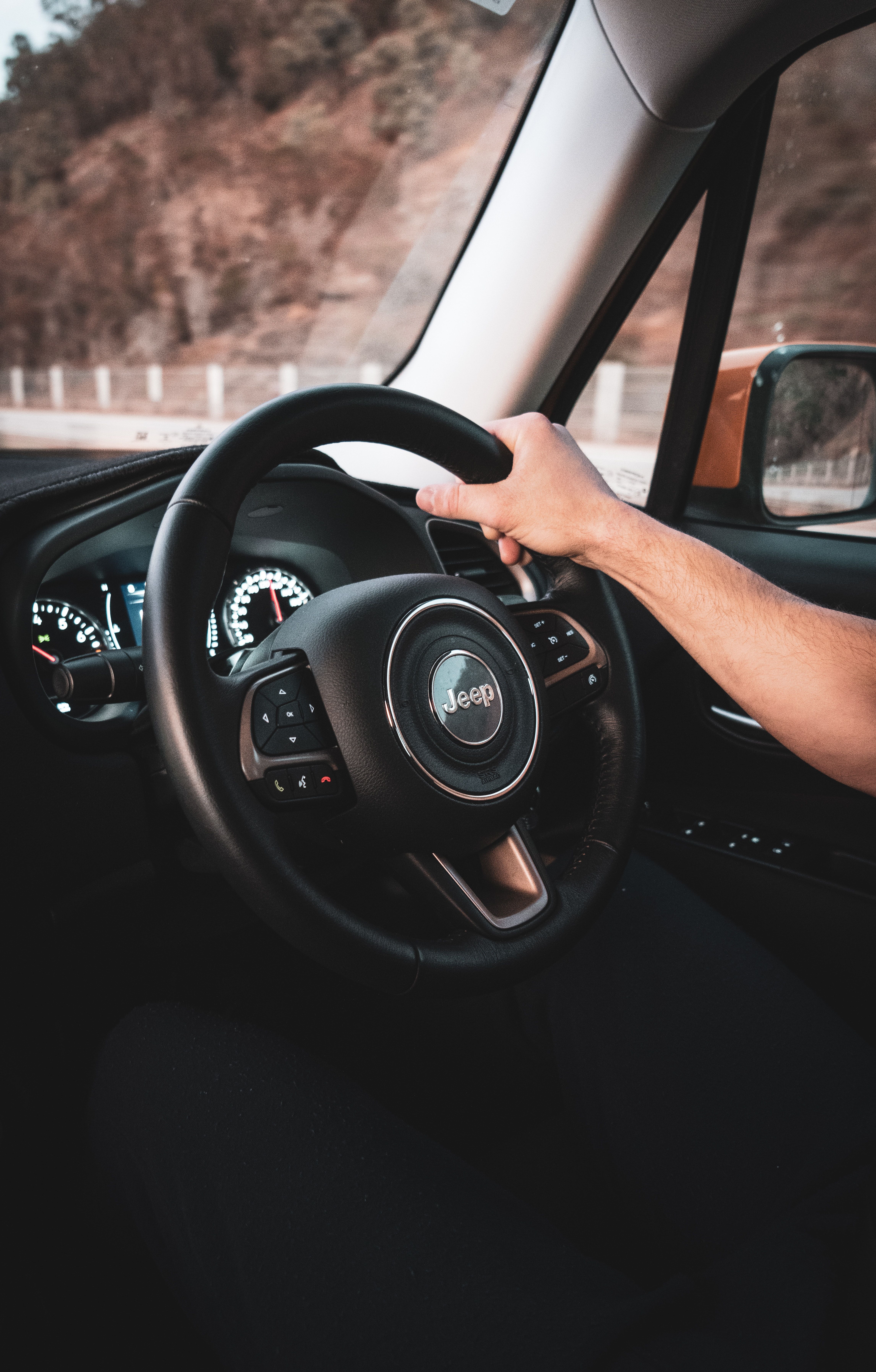 Person's Hand on Jeep Steering Wheel · Free