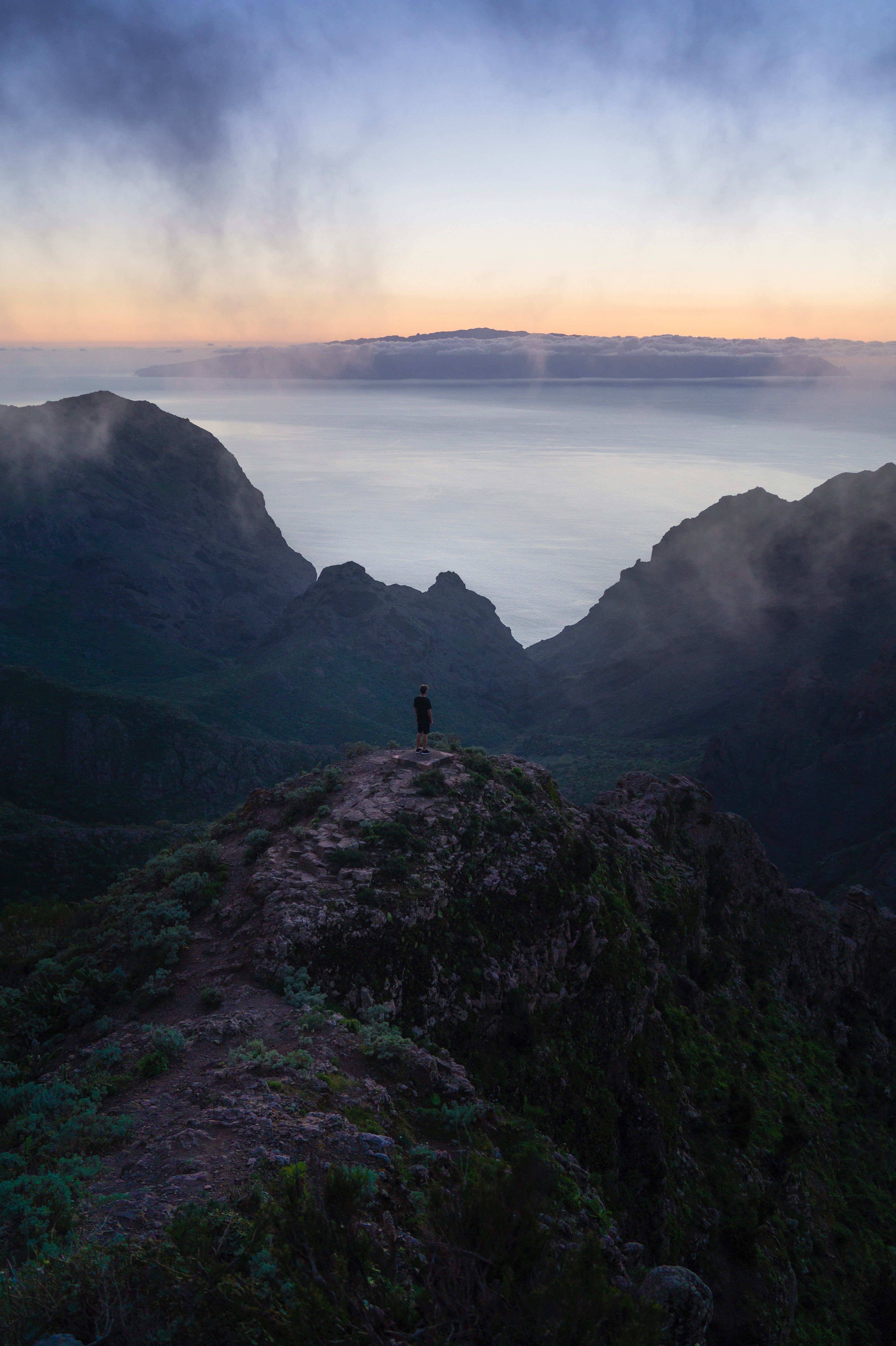 Wallpaper / hiker stands on a rocky mountain peak on a foggy day in masca, misty hikes in masca 4k wallpaper