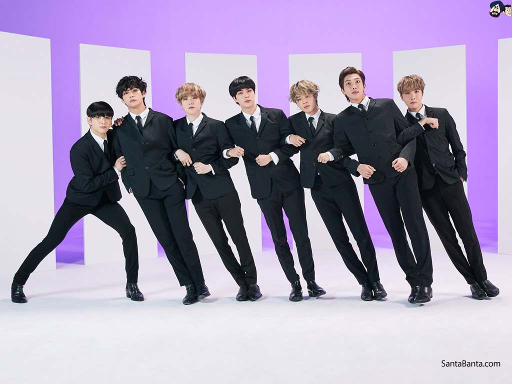 Team of Bangtan Boys (BTS) dressed in black formal suits