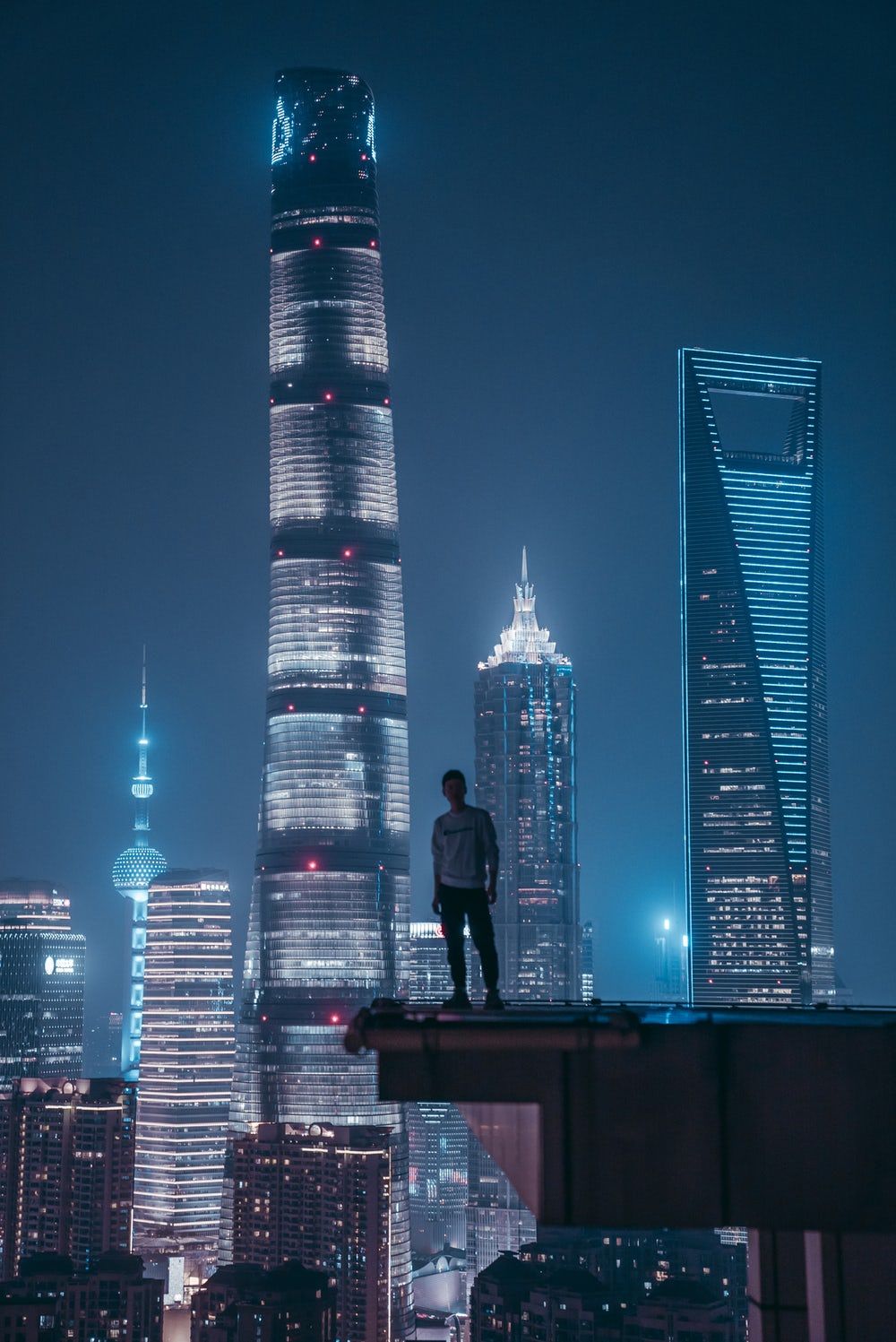 man standing on top of skyscraper. Skyscraper, Cyberpunk city, Futuristic city