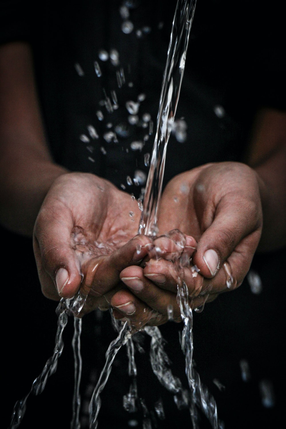 pouring water on person's hands photo