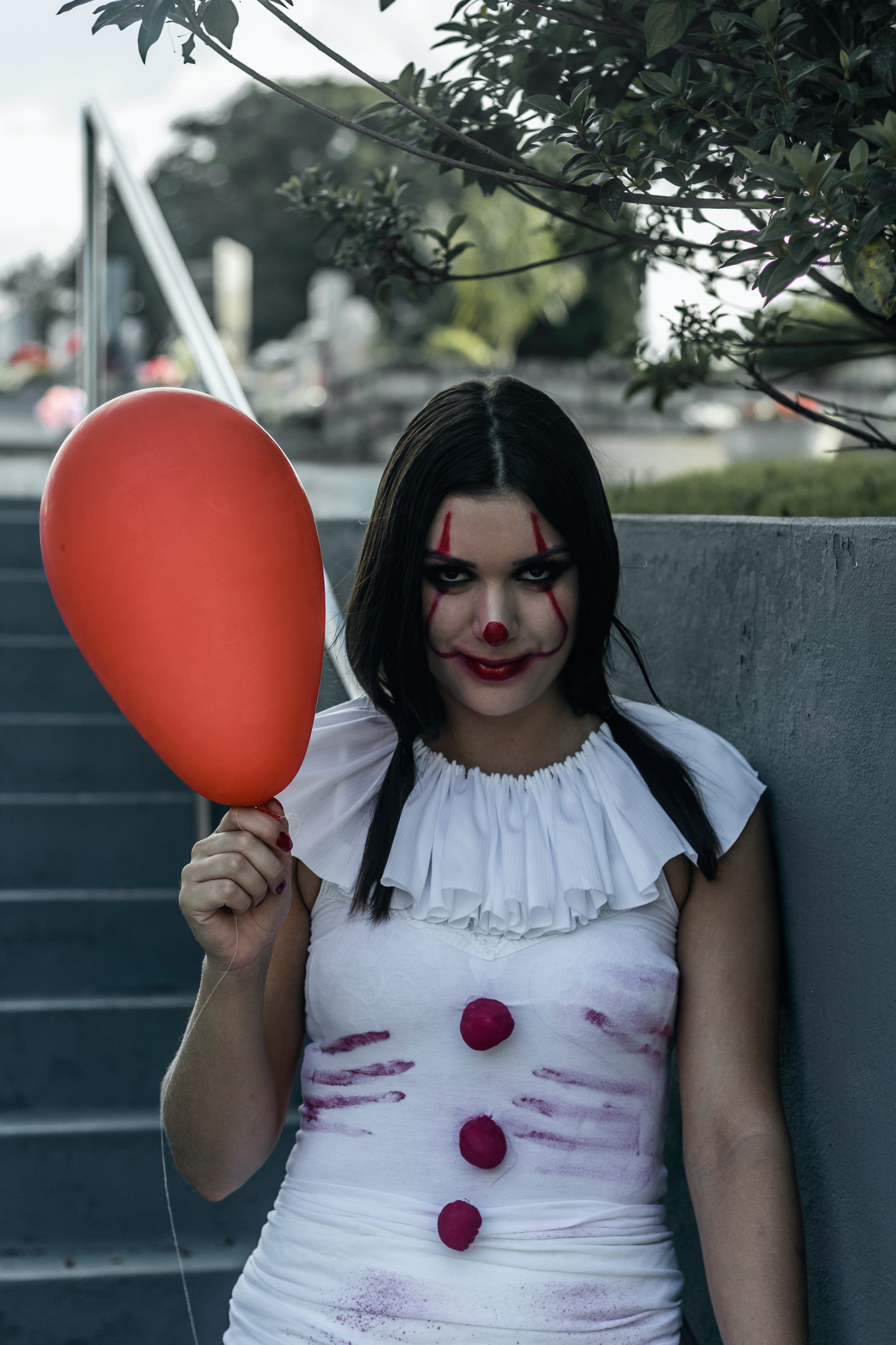 Creepy girl with clown makeup and balloon · Free
