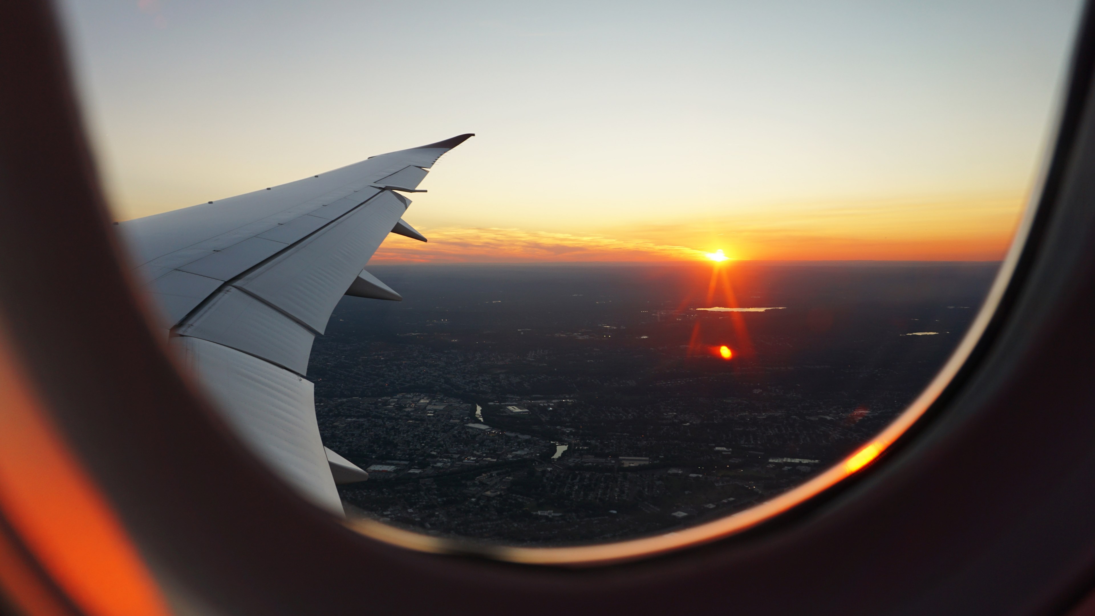 Wallpaper / a view from an airplane window on the sun setting on the horizon, sunset seen from a plane 4k wallpaper