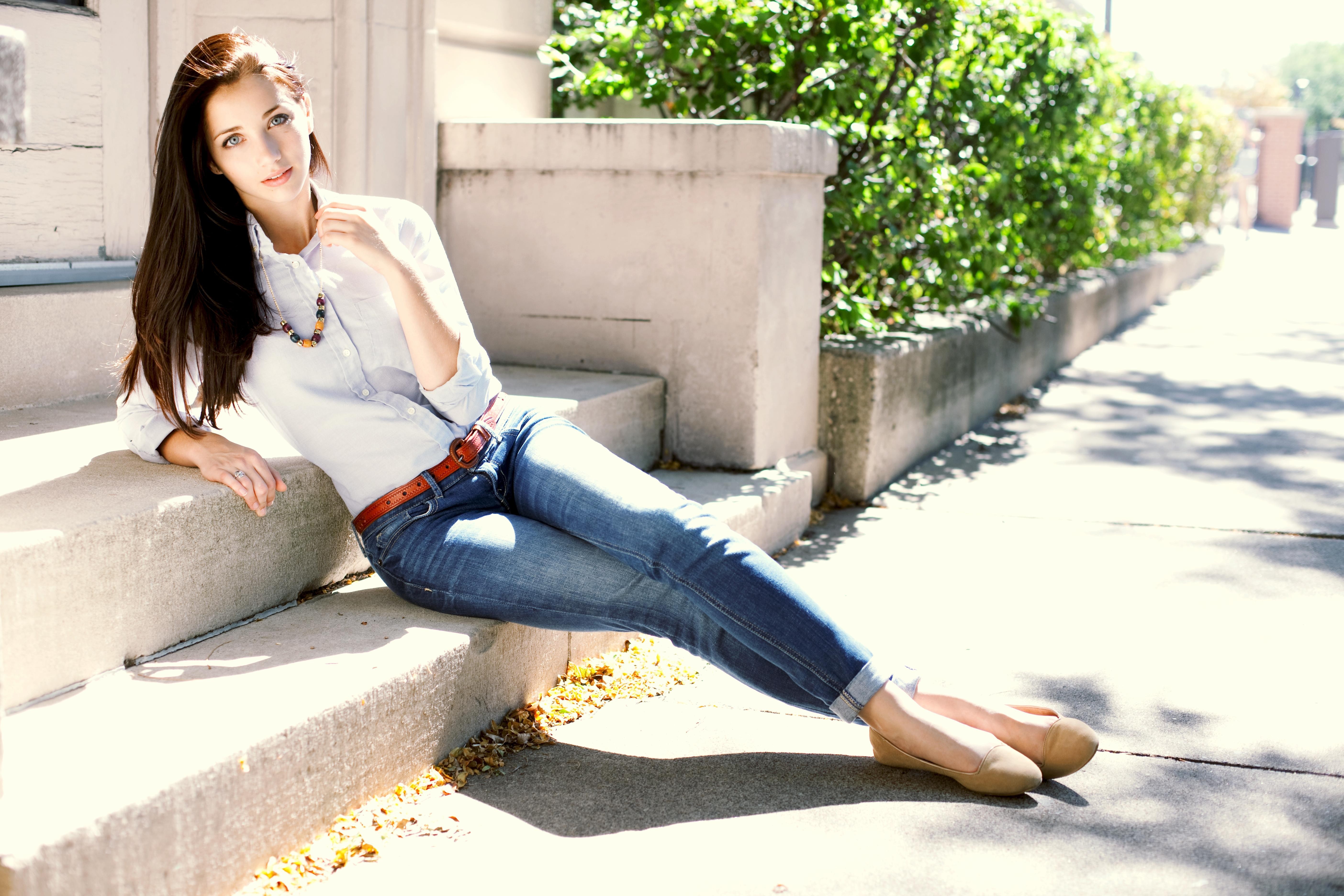 women, Emily Rudd, model, long hair, necklace, jeans, blue eyes, brunette, lying down, belt, white shirt wallpaper