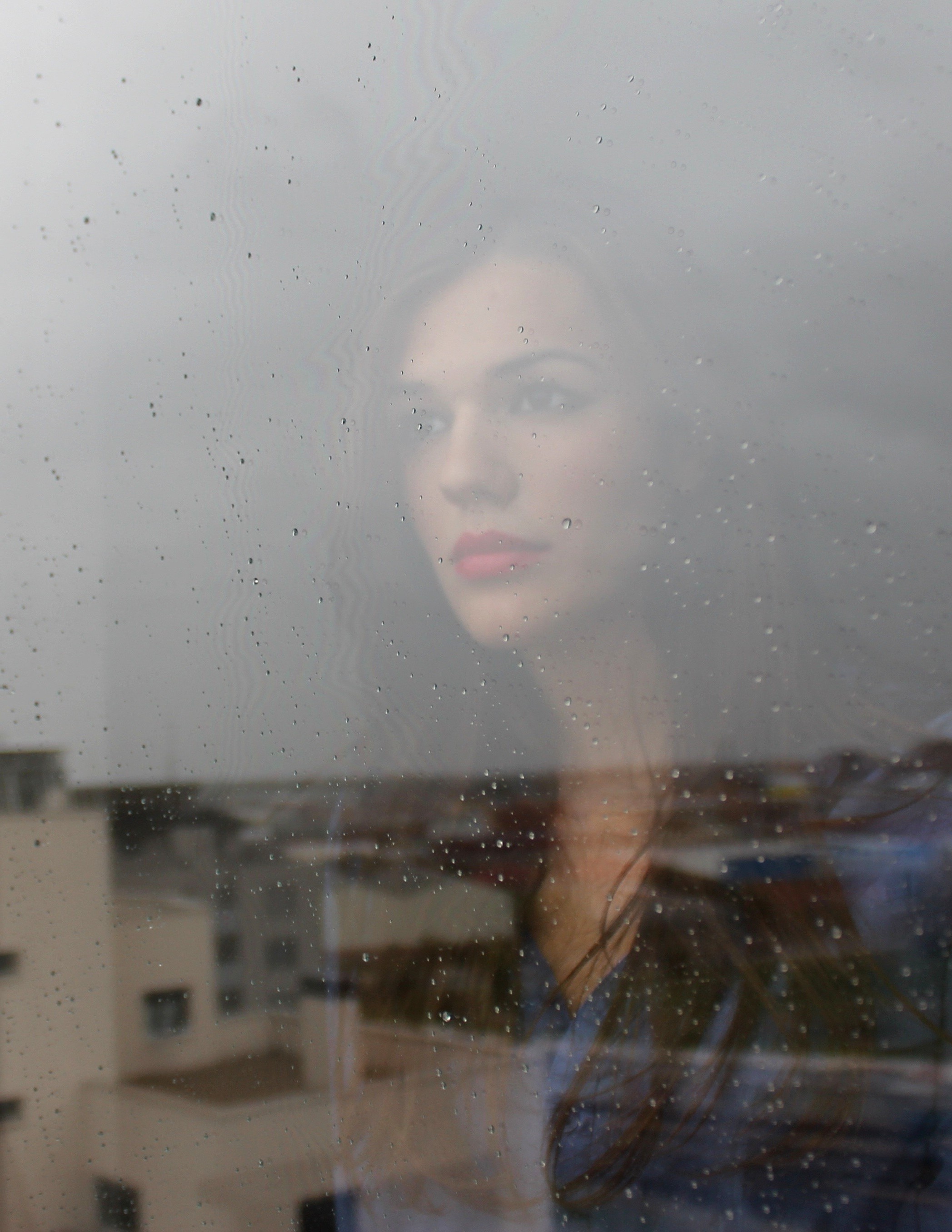 women, Model, Brunette, Long Hair, Looking Away, Face, Portrait, Portrait Display, Window, Glass, Rain, Water Drops, Urban, Building, Rooftops, Reflection, Red Lipstick, Blue Clothing Wallpaper HD / Desktop and Mobile Background