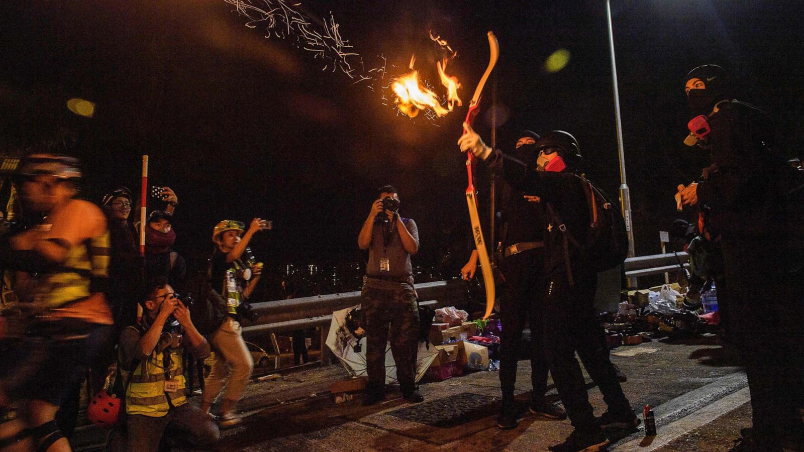 Hong Kong protesters wielding bows and arrows hunker down